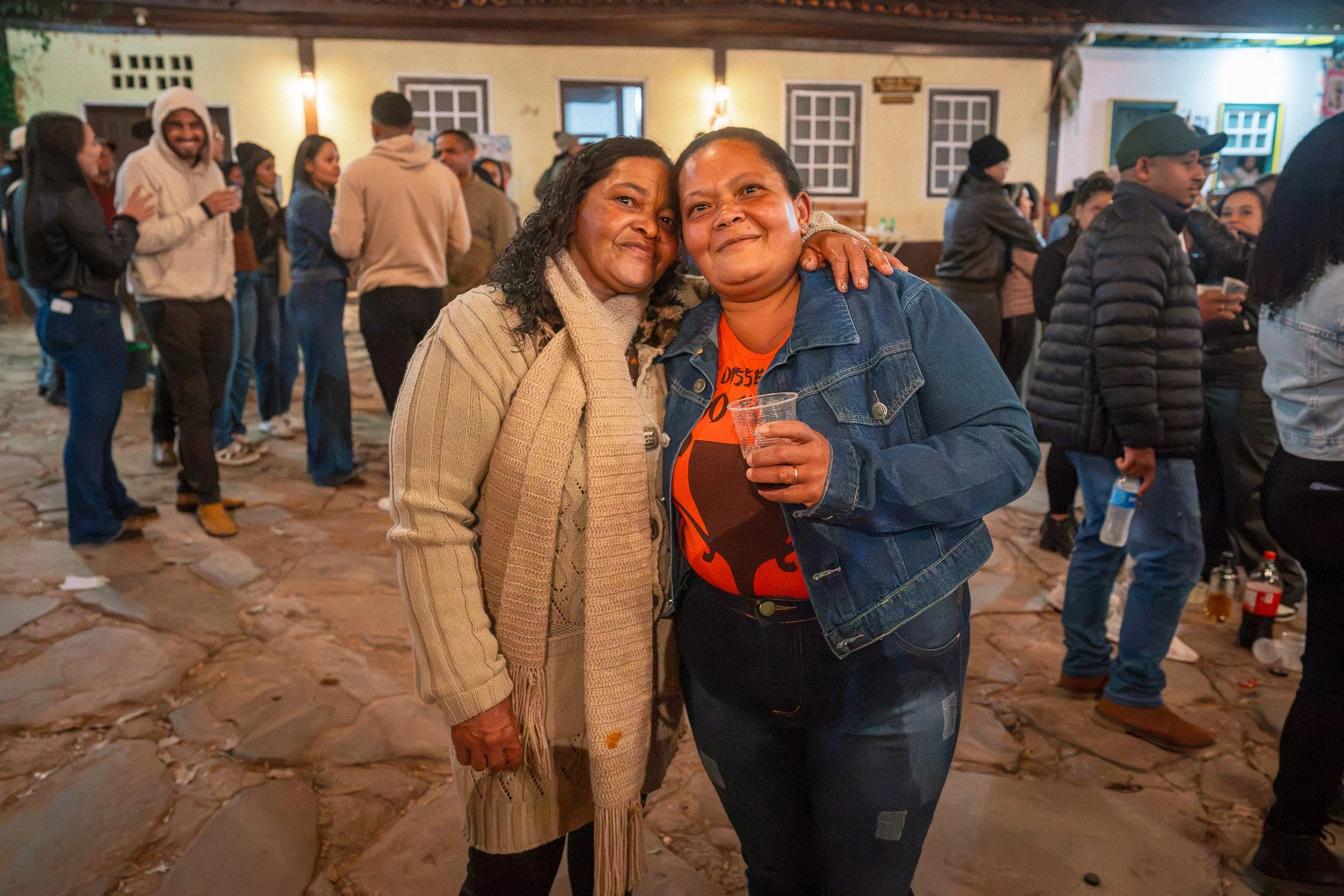 Dica and Carminha hugging at the festa junina in São Gonçalo do Rio das Pedras, Minas Gerais