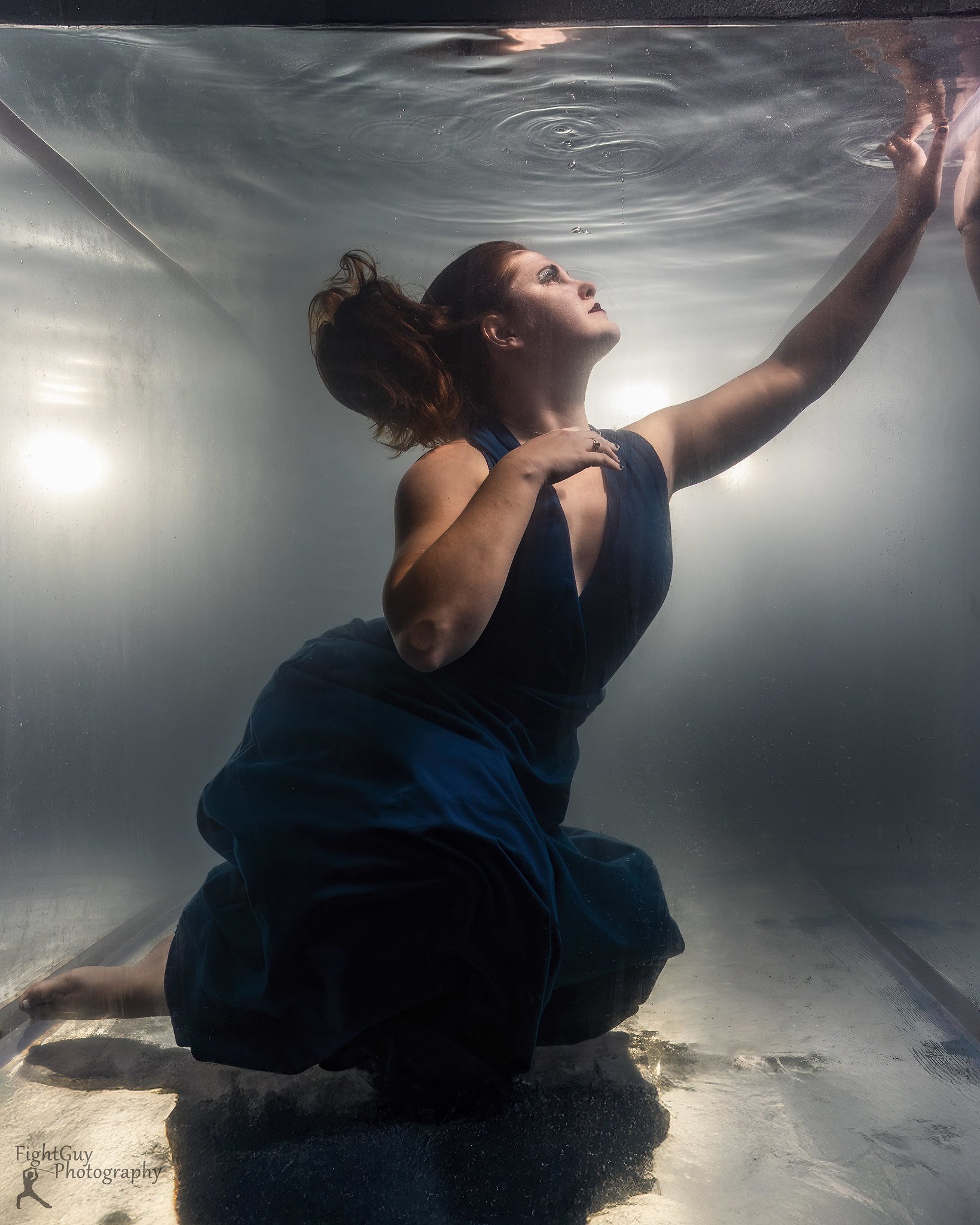 Beautiful woman underwater in a blue dress, professional underwater portrait session