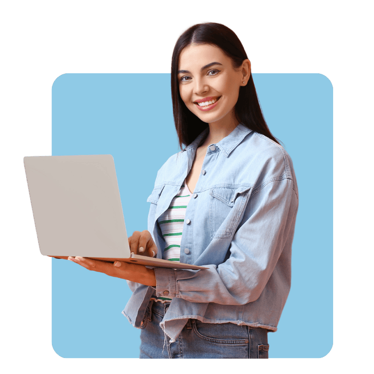 woman in jean jacket holding a laptop