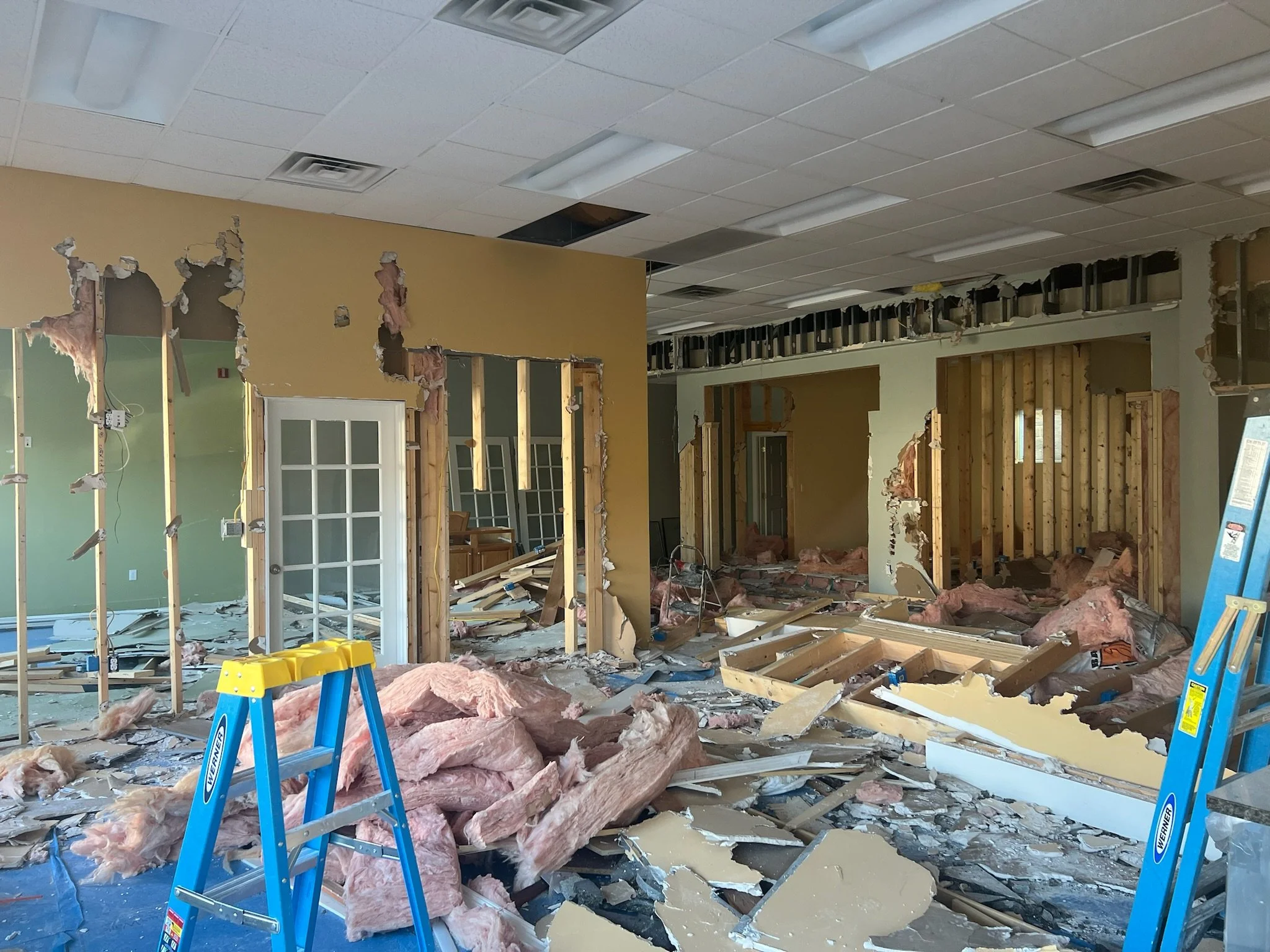 Commercial demolition and renovation in progress. Professional construction site showing commercial buildout transformation with exposed framing and debris removal.