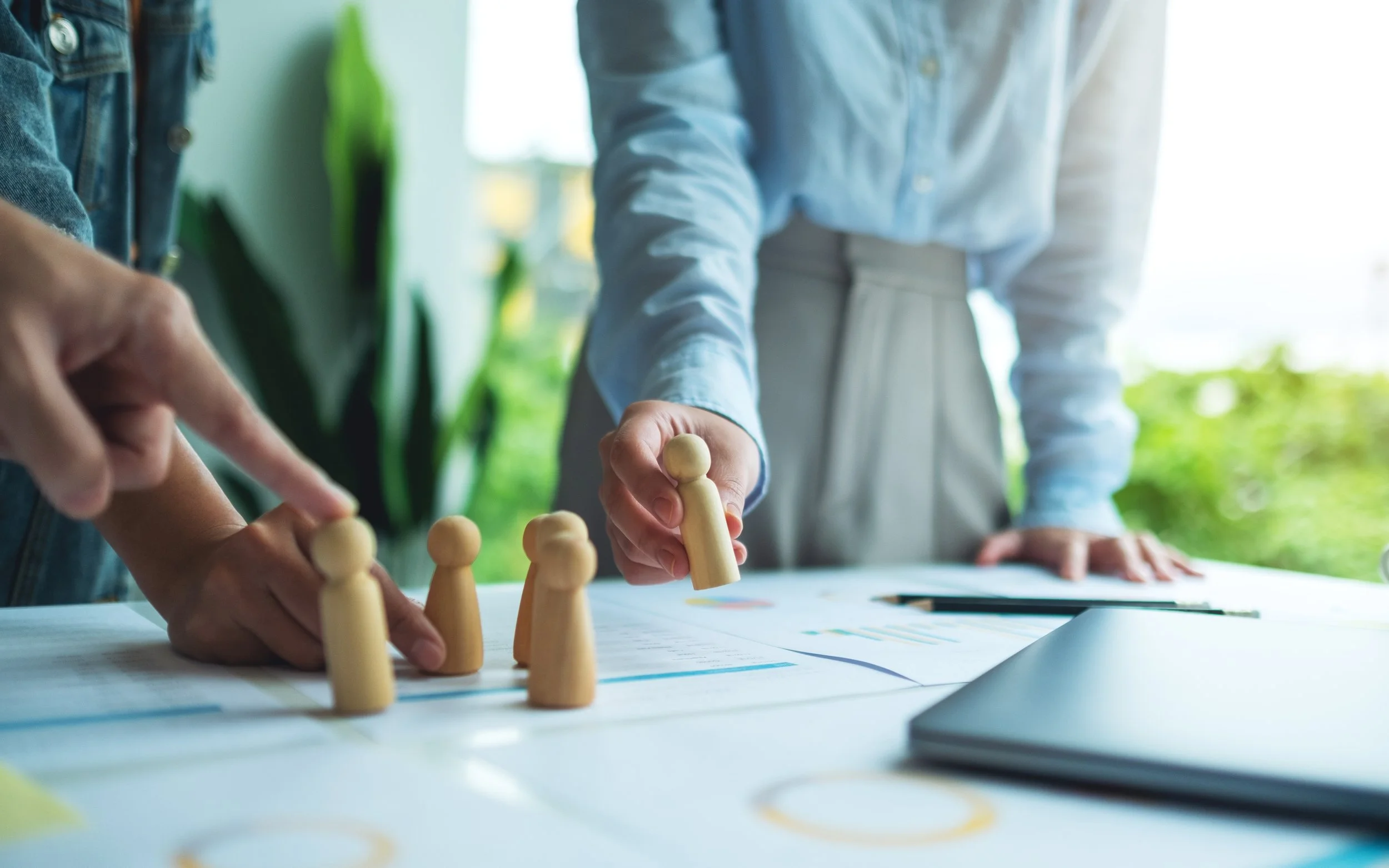 Image of people holding wooden figures for planning