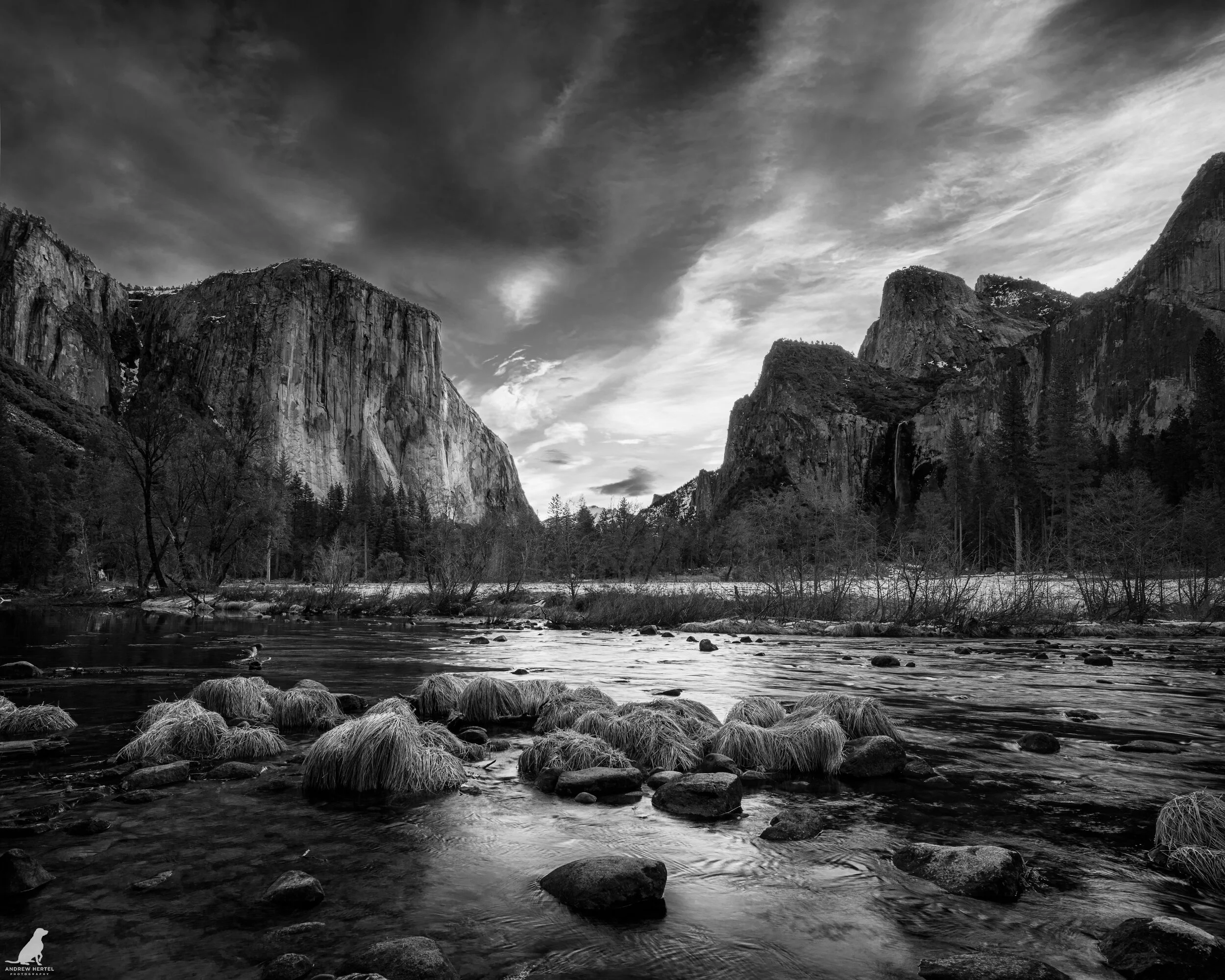 Fine art black and white photograph from the Merced River at Valley View in Yosemite National park with El Capitan and Half Dome in the background