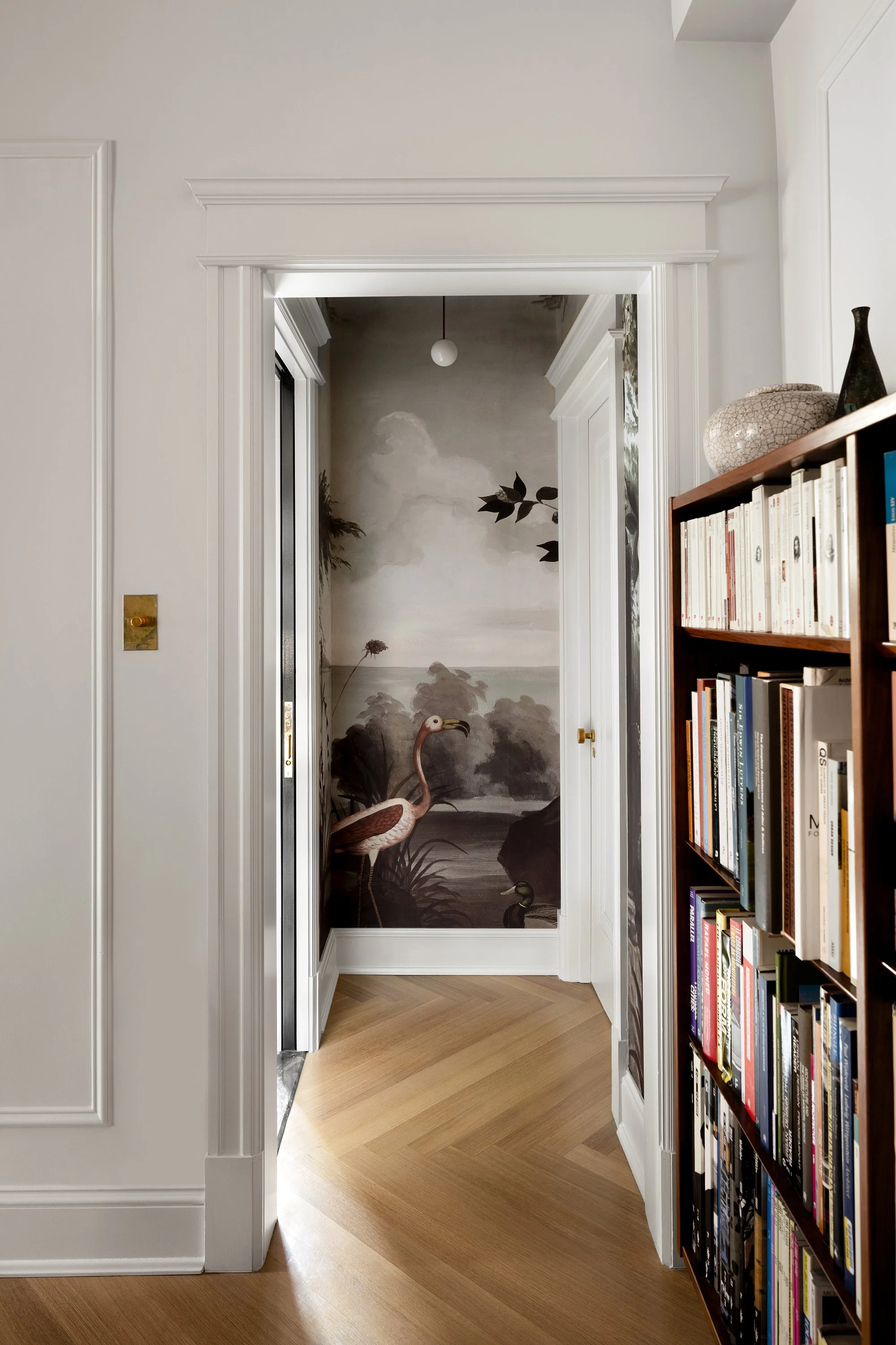 An alcove in an apartment designed by architect Nicholas Potts featuring a panoramic wallpaper with a flamingo