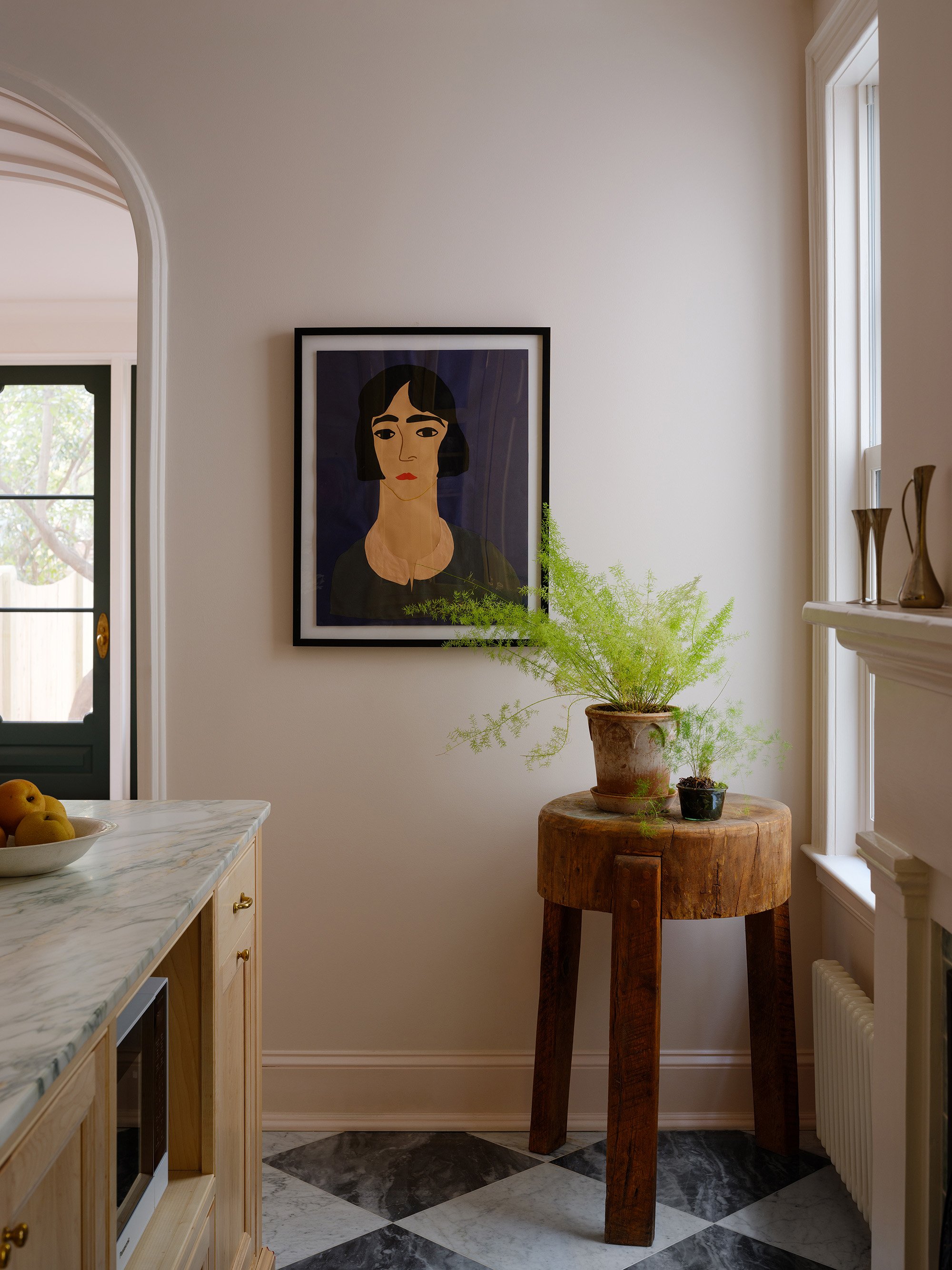 A vignette with a plant and painting in the kitchen of an historic row house on Capitol Hill