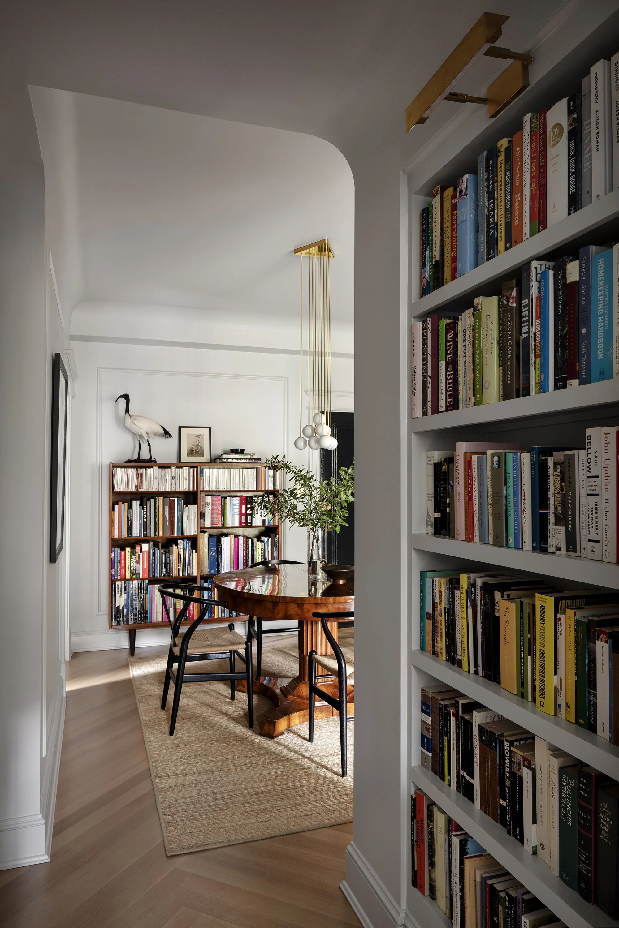 A dining room in an apartment designed by architect Nicholas Potts with an antique Biedermeier table and a bookshelf