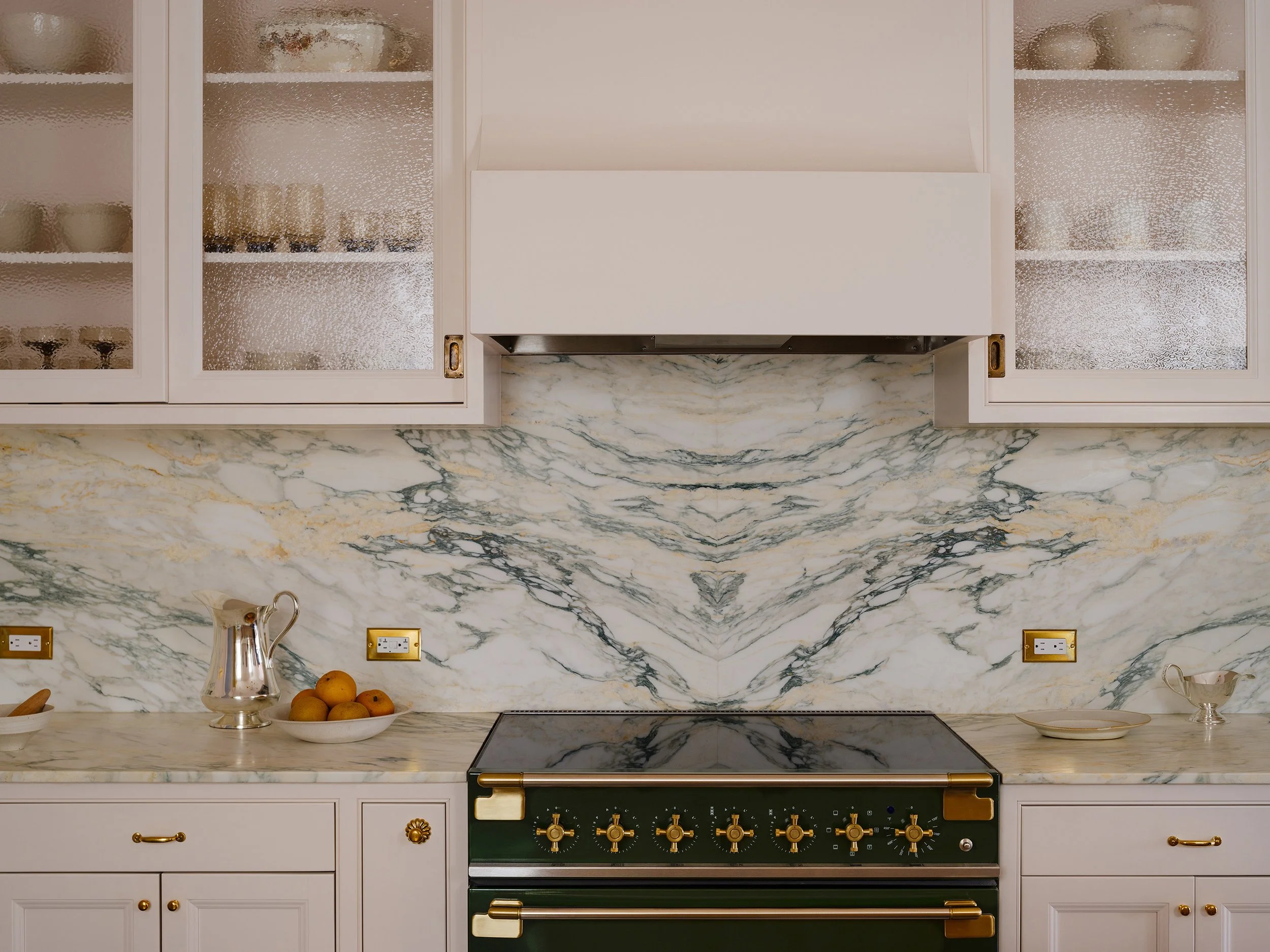 Pink cabinets and a marble backsplash kitchen designed by architect Nicholas Potts