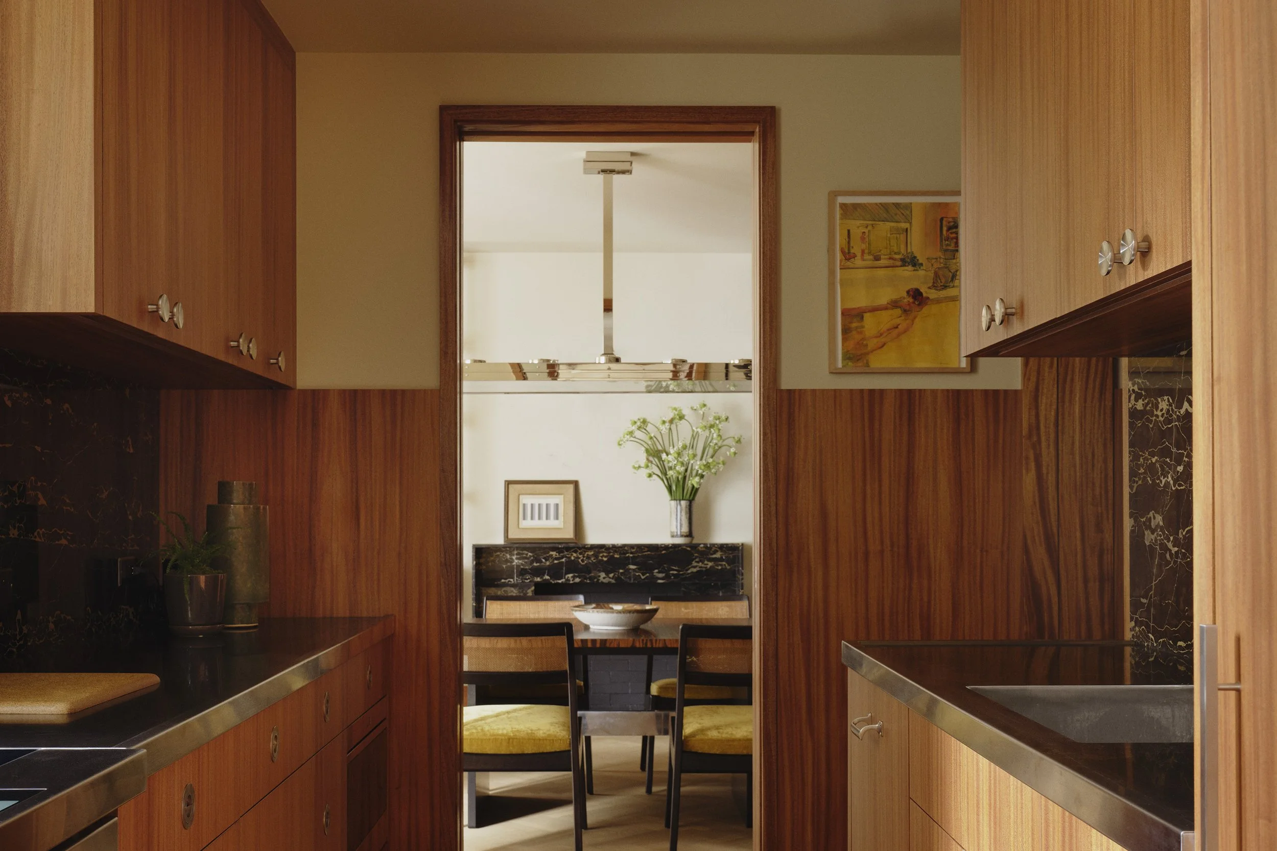 Kitchen with Khaya Mahogany paneling and Portoro Marble backsplash and fireplace deisgned by Nicholas Potts