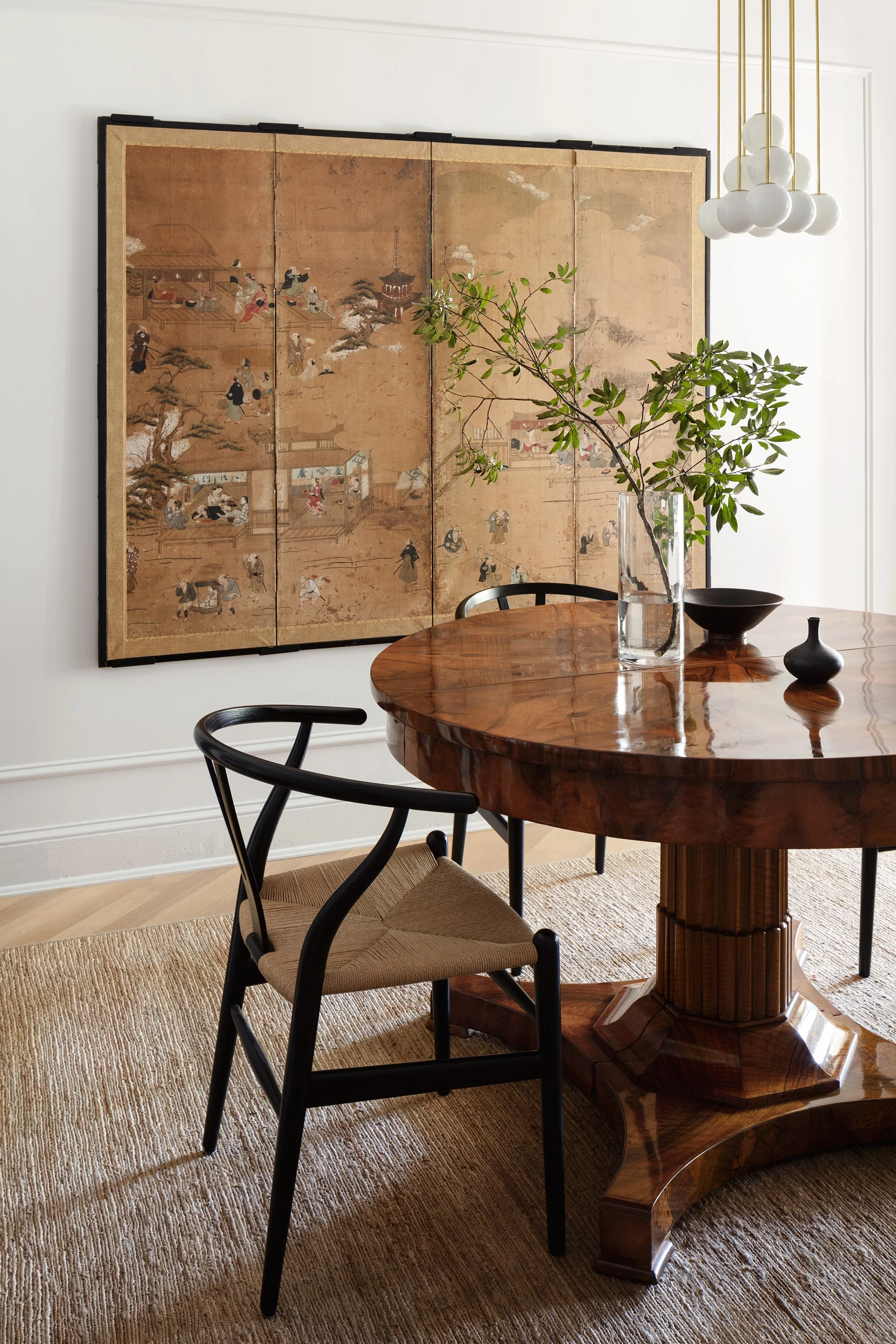 A dining room with an antique Japanese screen and a Biedermeier table