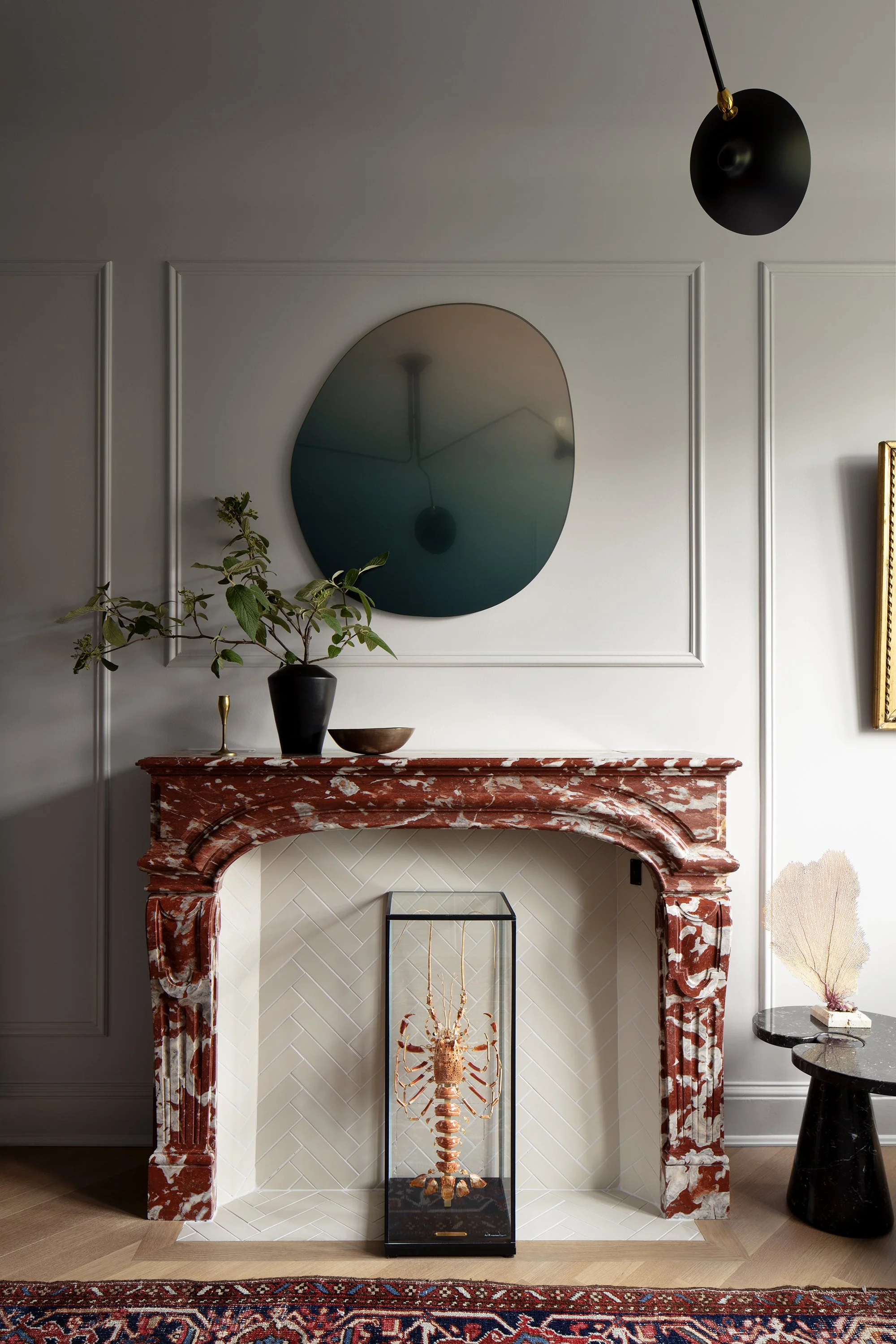 A red marble fireplace in an apartment designed by architect Nicholas Potts and a lobster