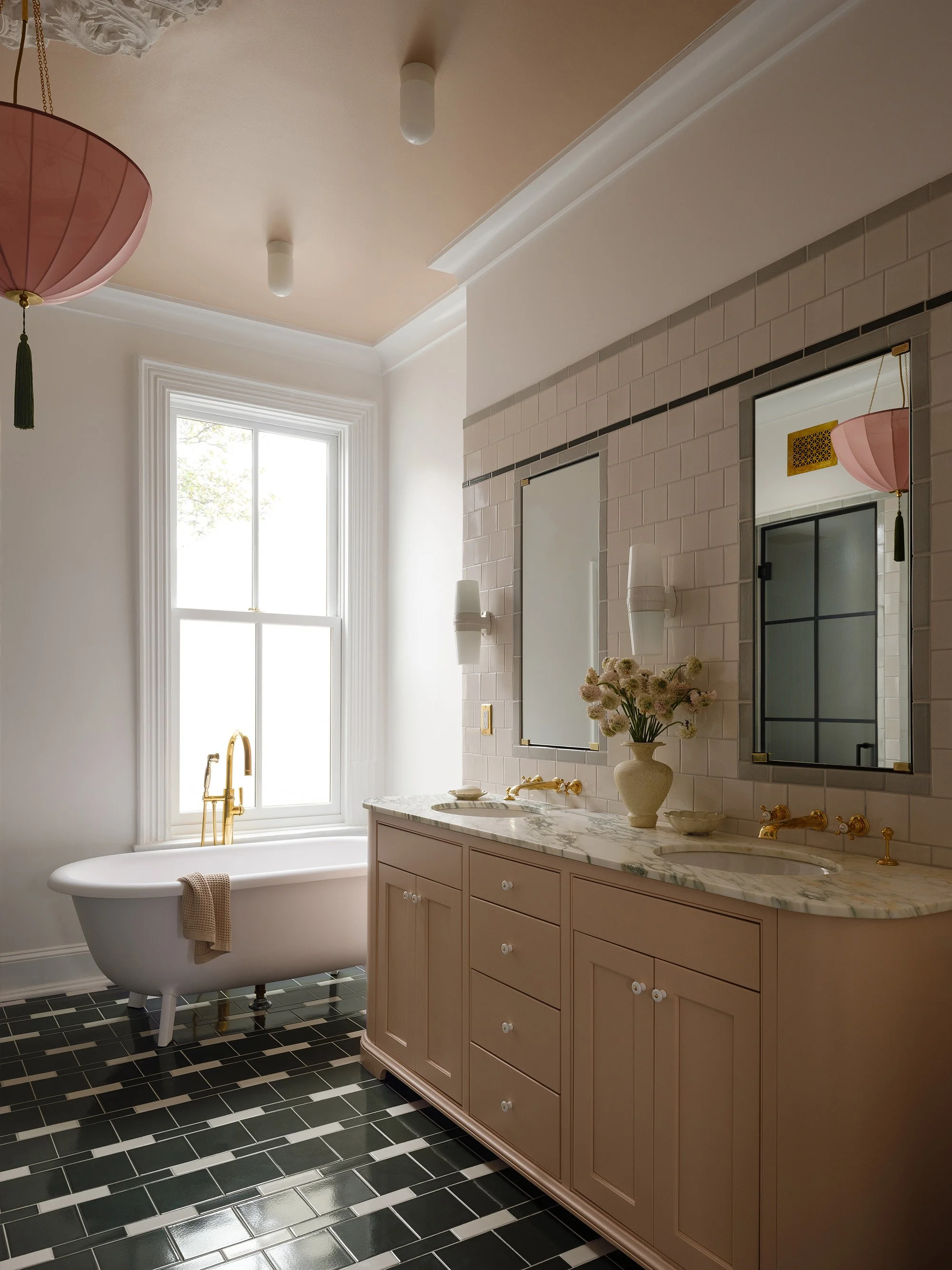 A bathroom with a bold tiled floor, a fabric lamp, and a pink ceiling in Capitol Hill