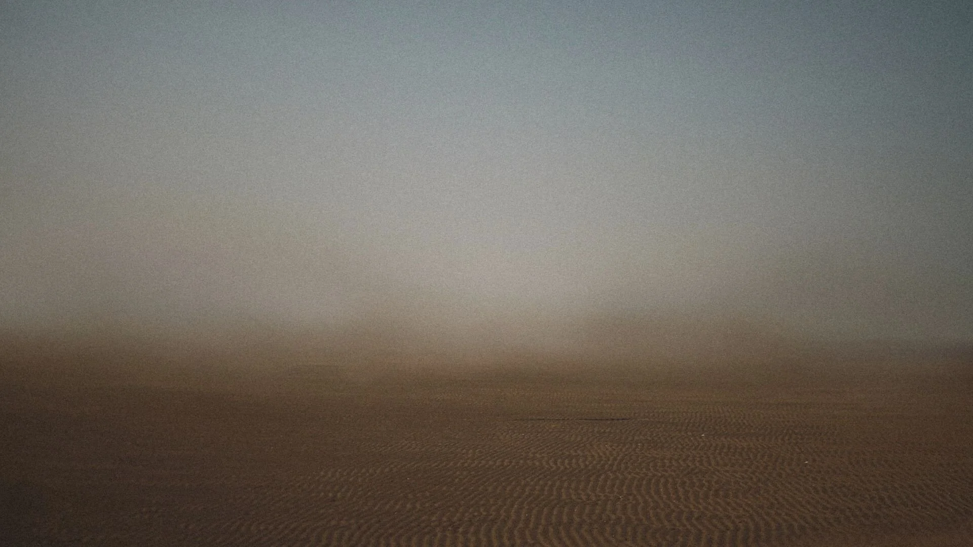 A grainy, brown sandy background texture.