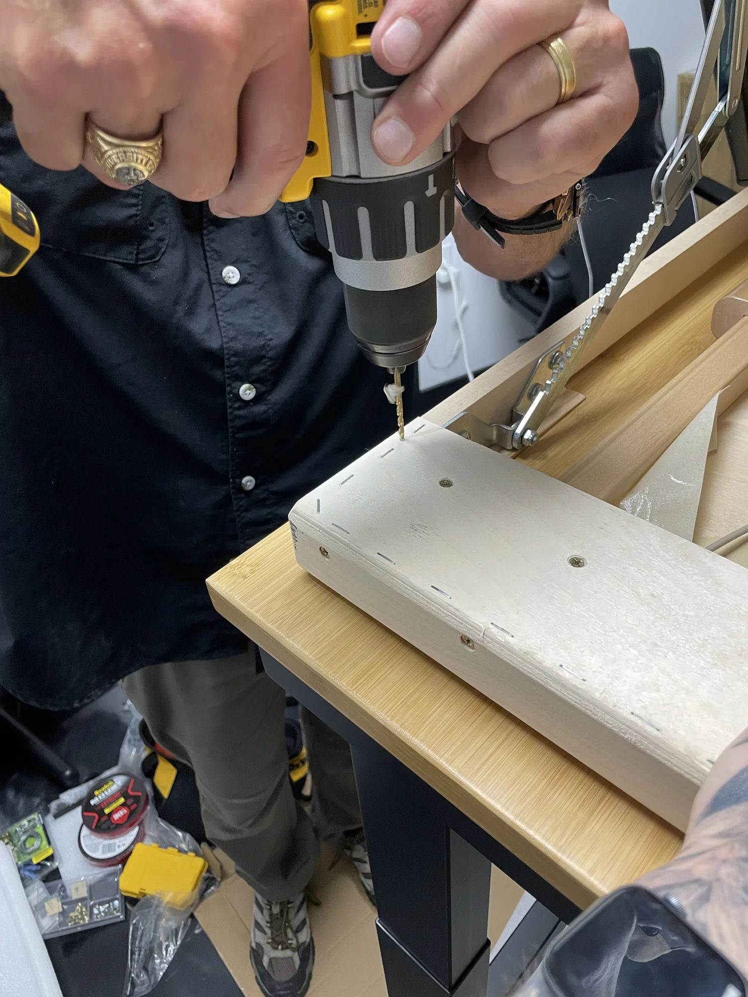 Screw driven through frame, shim, and into tabletop