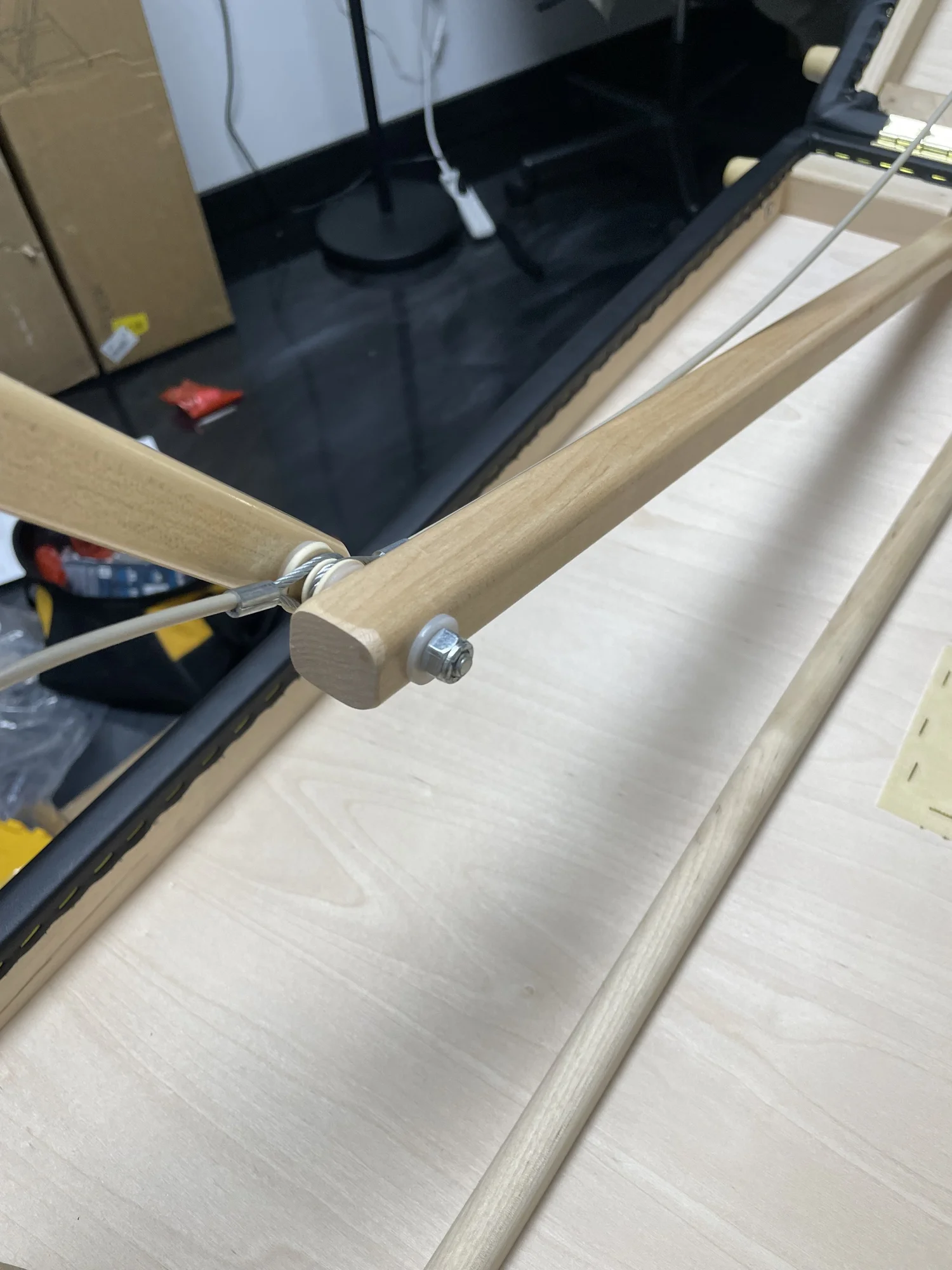 Tether attachment point on massage table leg joint