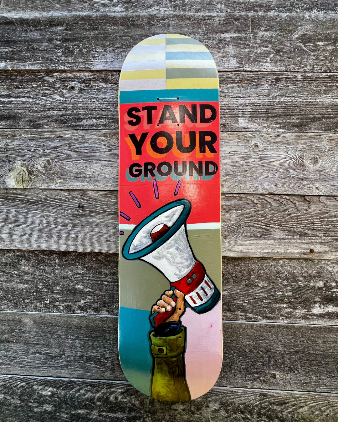 Stand Your Ground, mixed media on skateboard by Hoey Xōchitl, Zandra X and Timothy Wilson Hoey, 8.5x32.5 inches, 2026