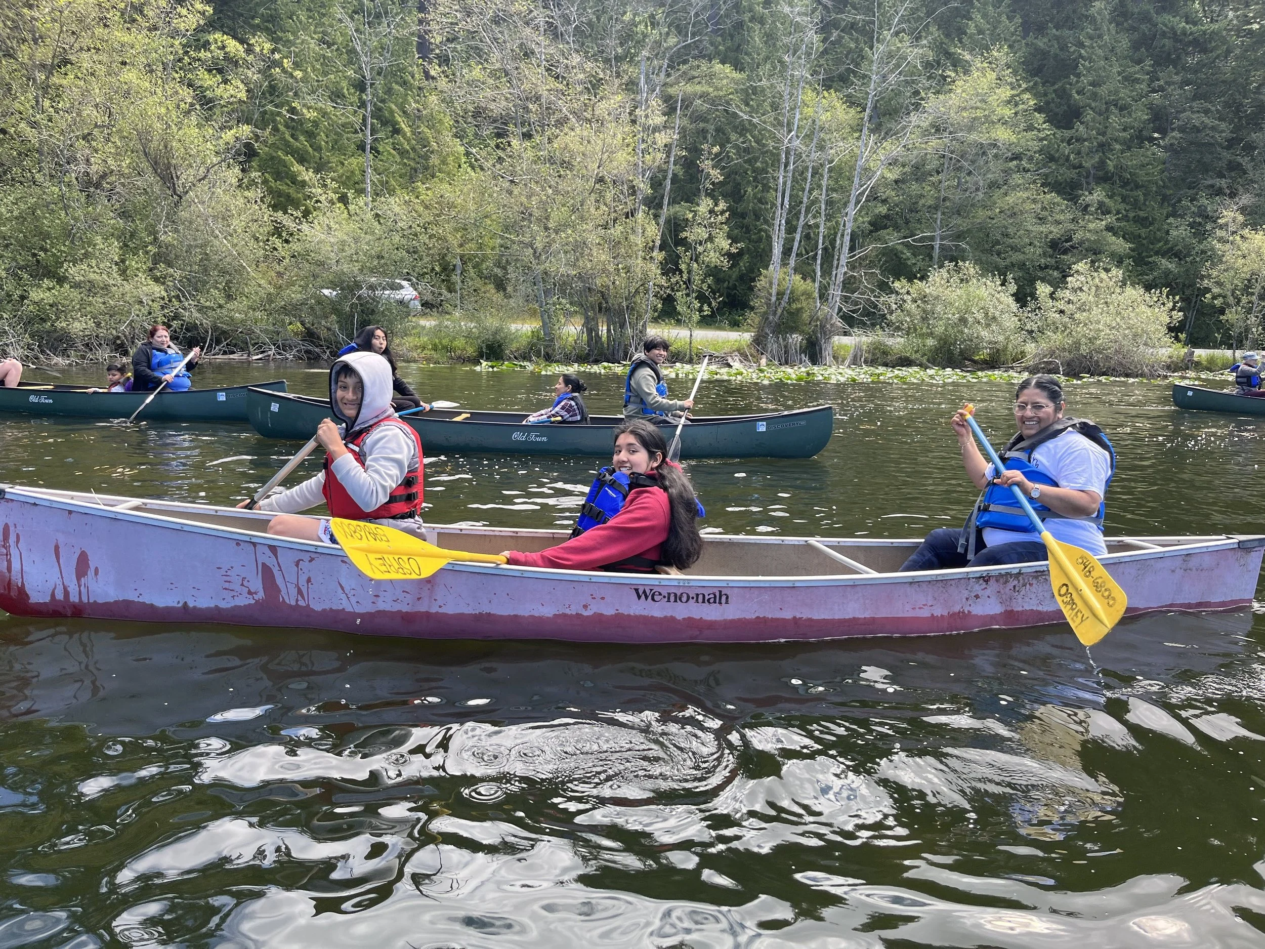 youth and adults rowing in canoes at heart lake kulshan creek neighborhood youth program