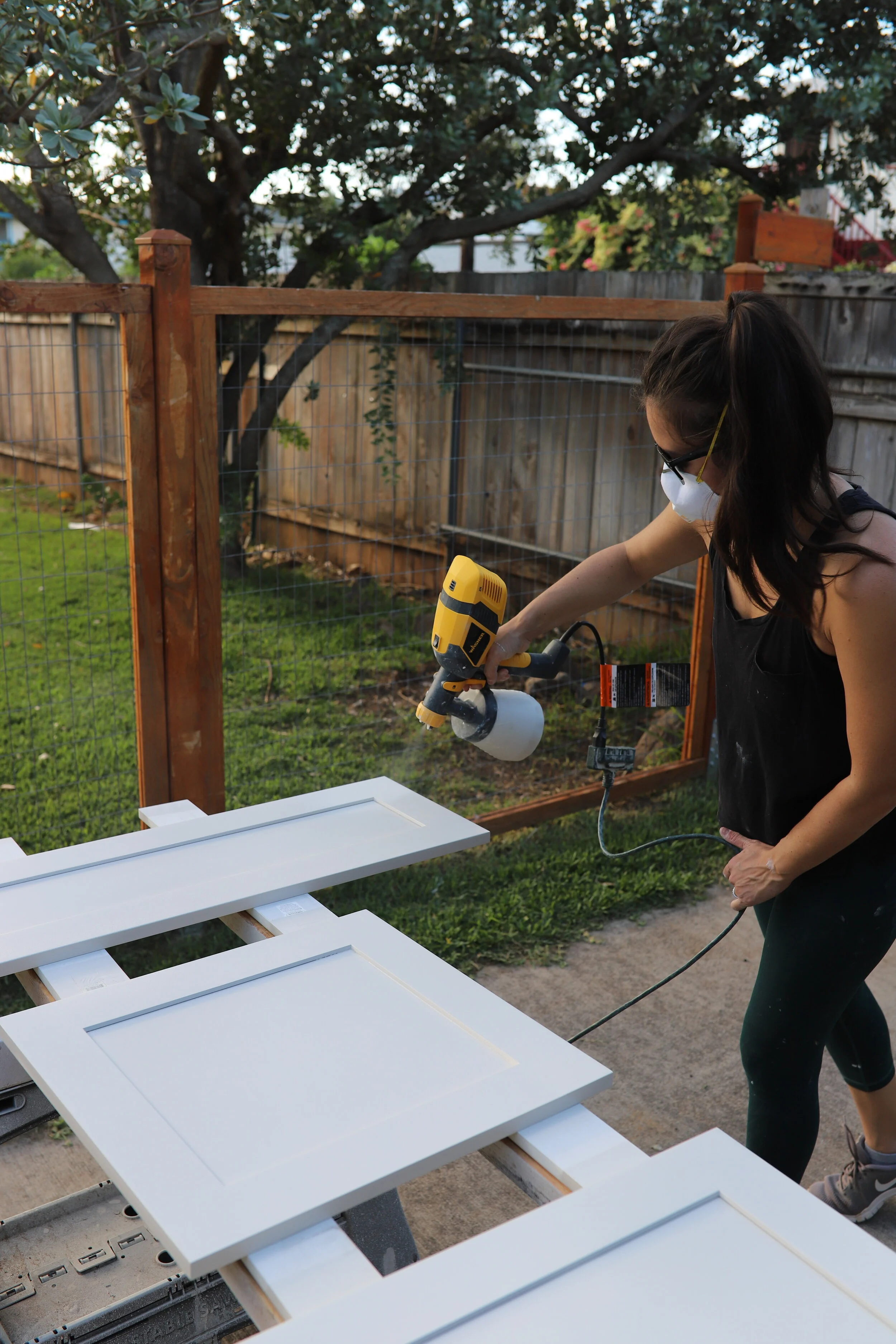 woman using paint sprayer