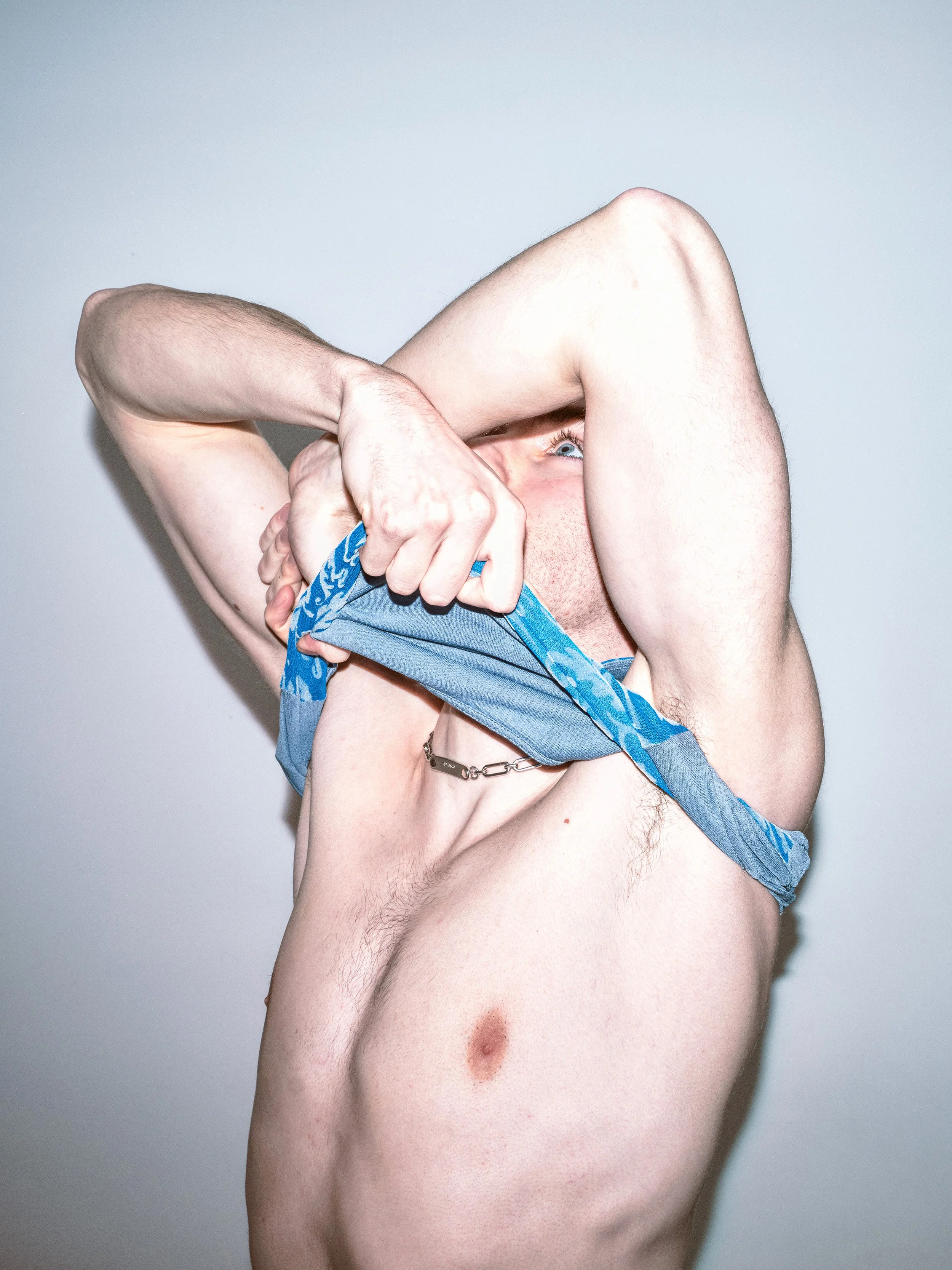 Portrait photograph by London based photographer Maxwell Anderson of artist model Todd Lamming shot for a fashion editorial portraying a queer erotic and domestic banal interaction using flash photography.