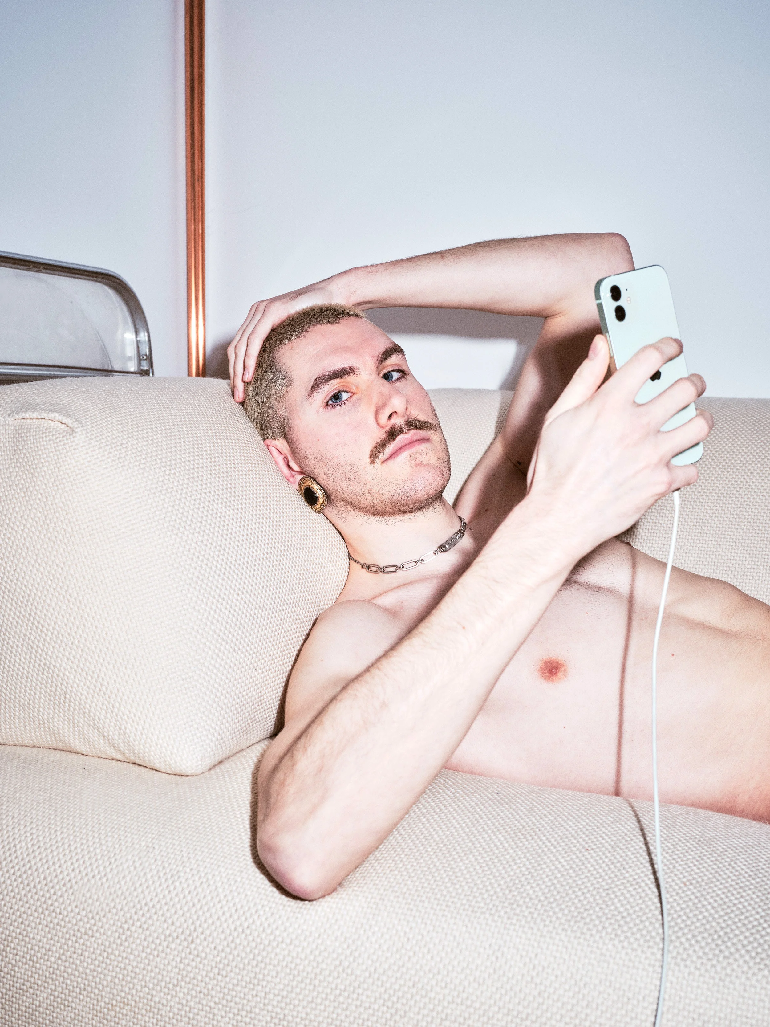 Portrait photograph by London based photographer Maxwell Anderson of artist model Todd Lamming shot for a fashion editorial portraying a queer erotic and domestic banal interaction using flash photography.