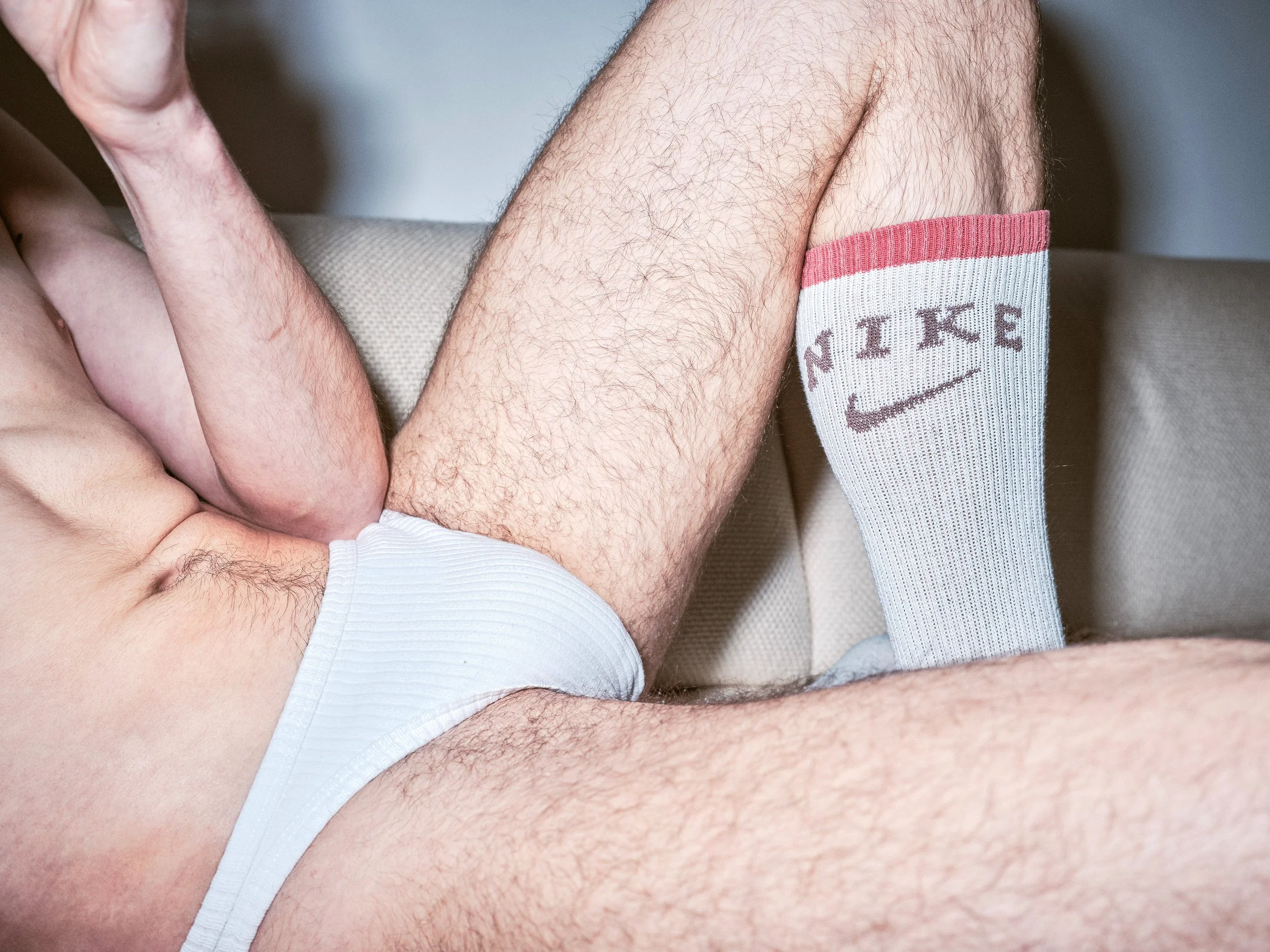 Portrait photograph by London based photographer Maxwell Anderson of artist model Todd Lamming shot for a fashion editorial portraying a queer erotic and domestic banal interaction using flash photography.