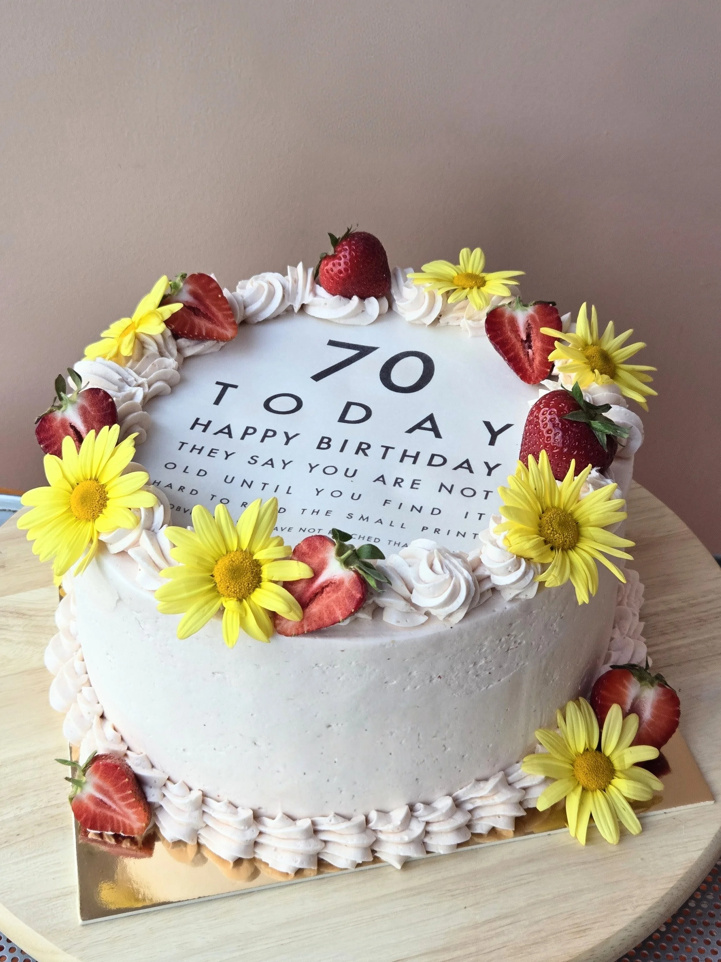 Funny birthday cake decorated with vintage piping edible flowers and fresh strawberries