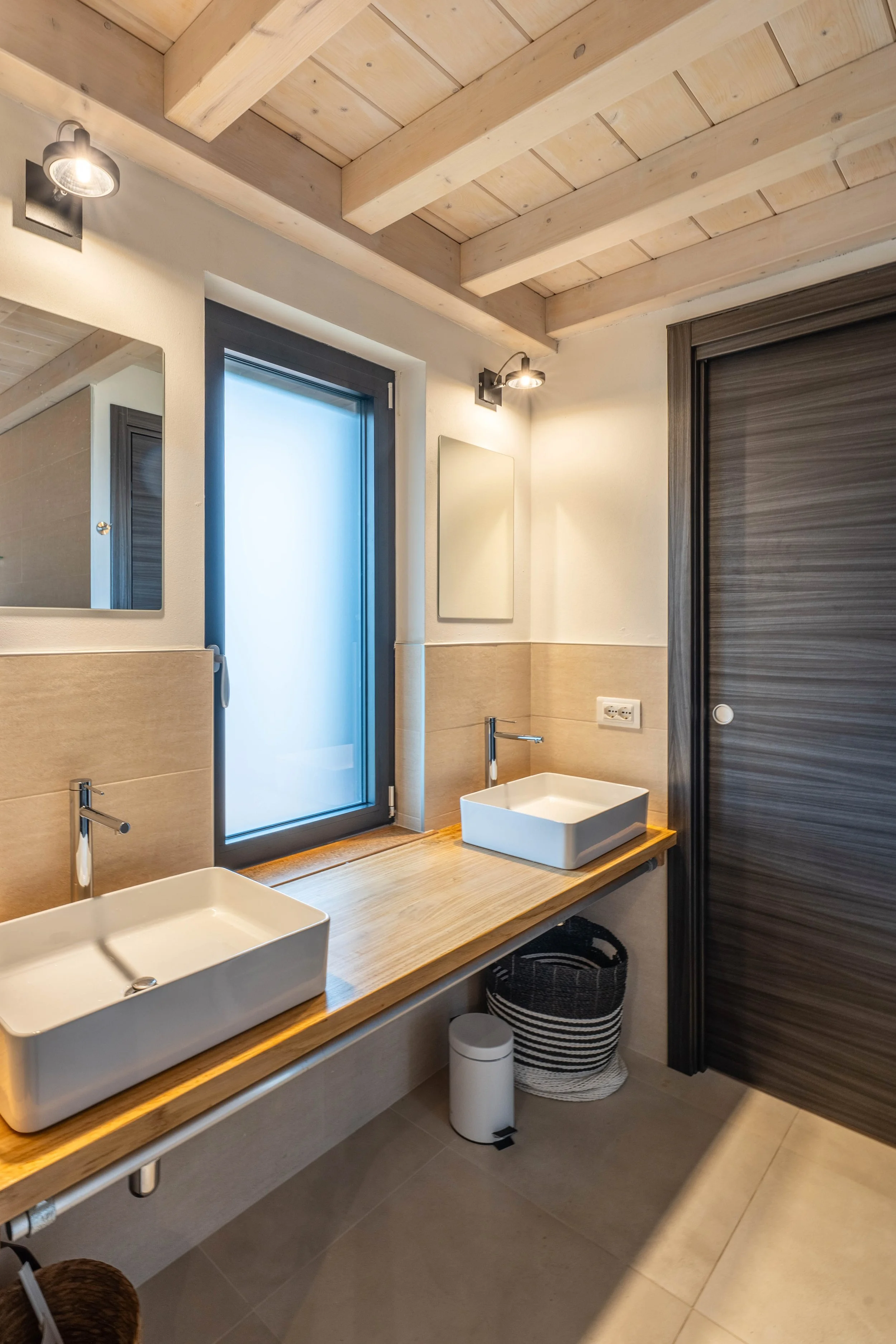 Moderne badkamer met dubbele gootsteen, houten spiegelkast, zwart deur, raam met frost фильроект, houten plafond, muurverlichting.