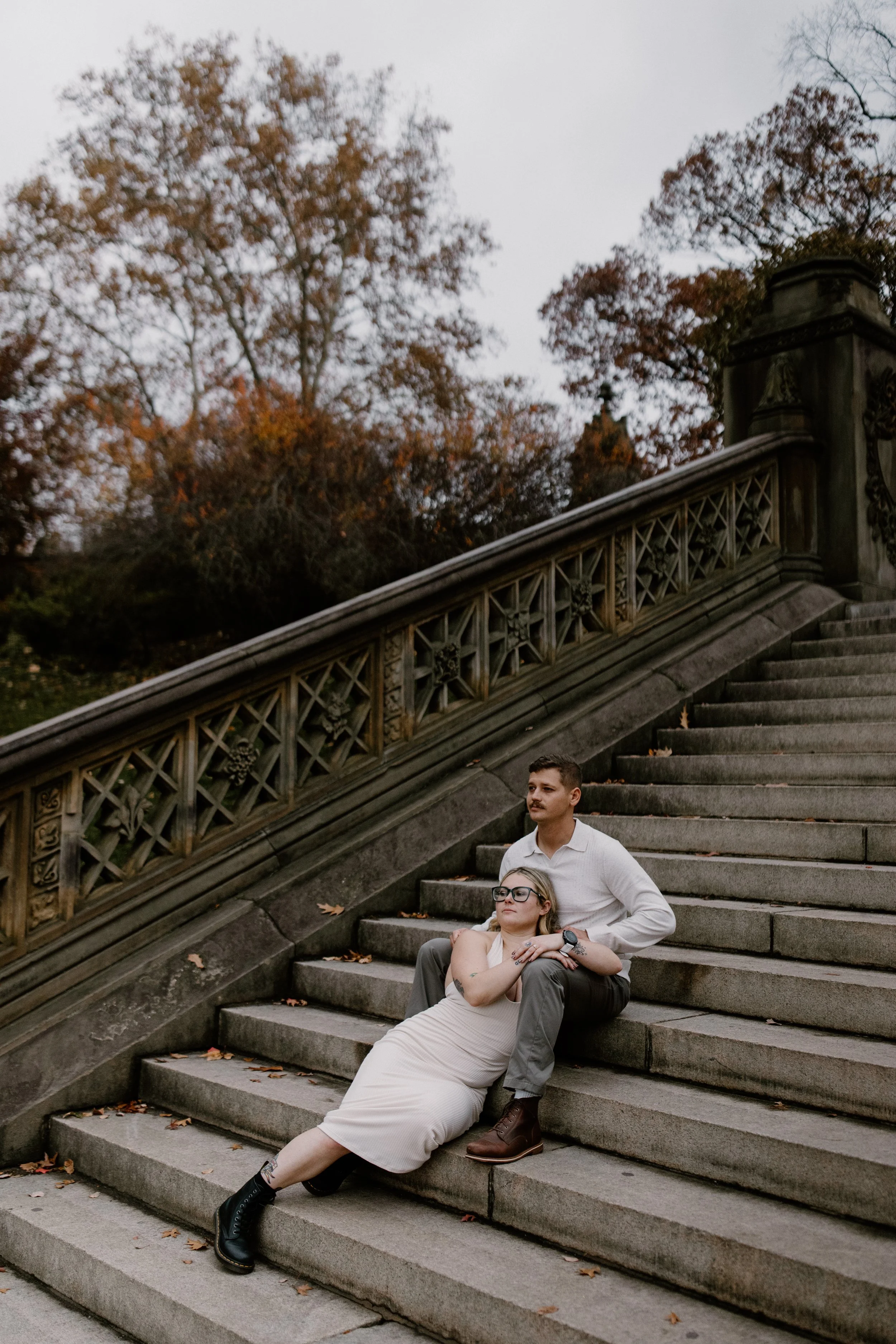 A man and woman sitting on stone steps at the Bethesda Terrace in Central Park NY 