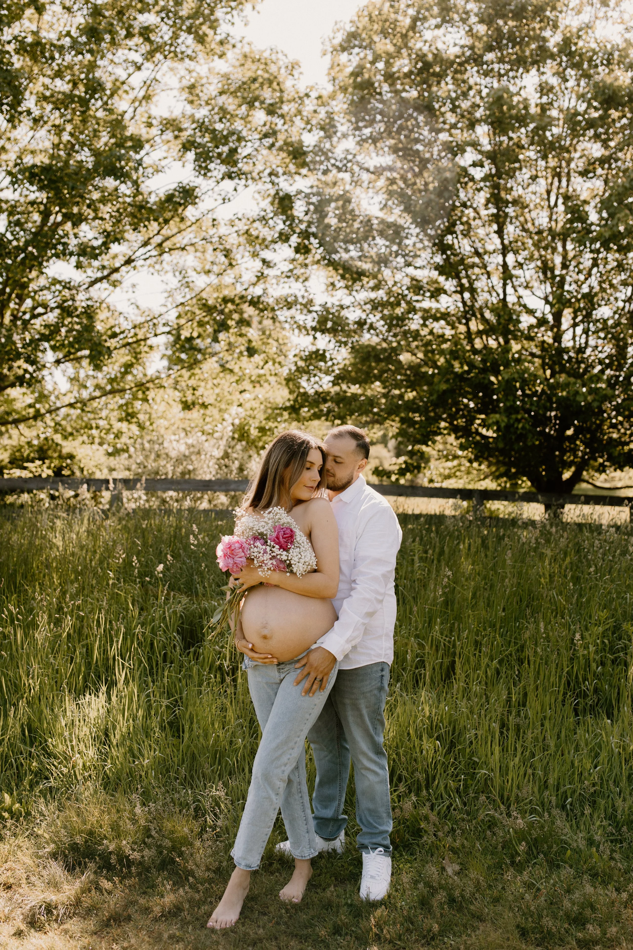 A wife poses with her husband for maternity photos in North Salem NY