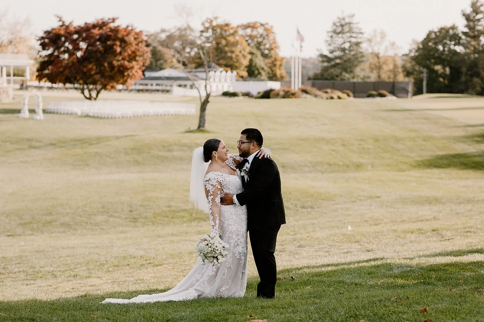 A bride and groom in wedding smile at each other. Wedding at the Knollwood Country Club in Westchester NY