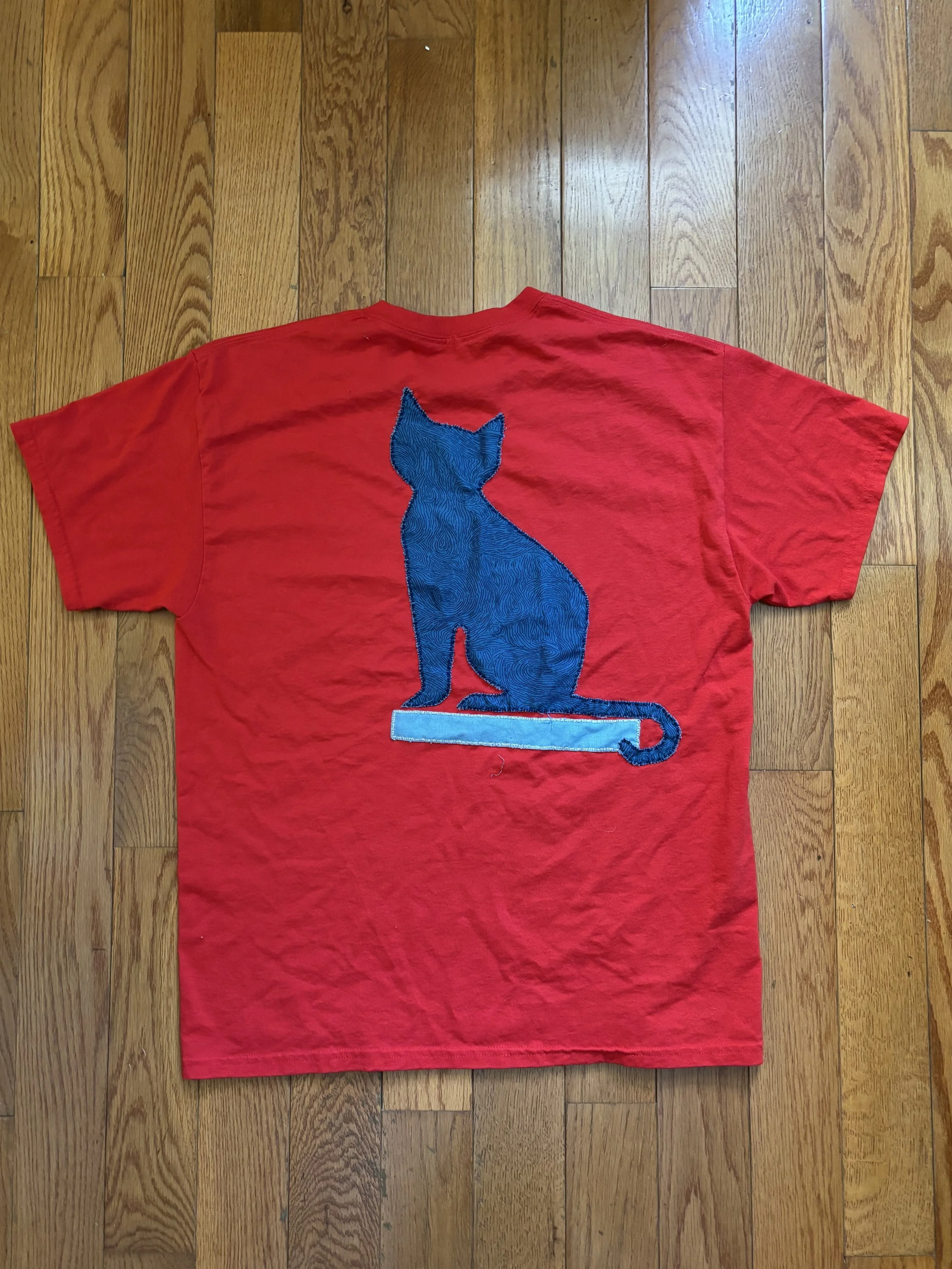 red t-shirt with blue cat appliquéd on the back