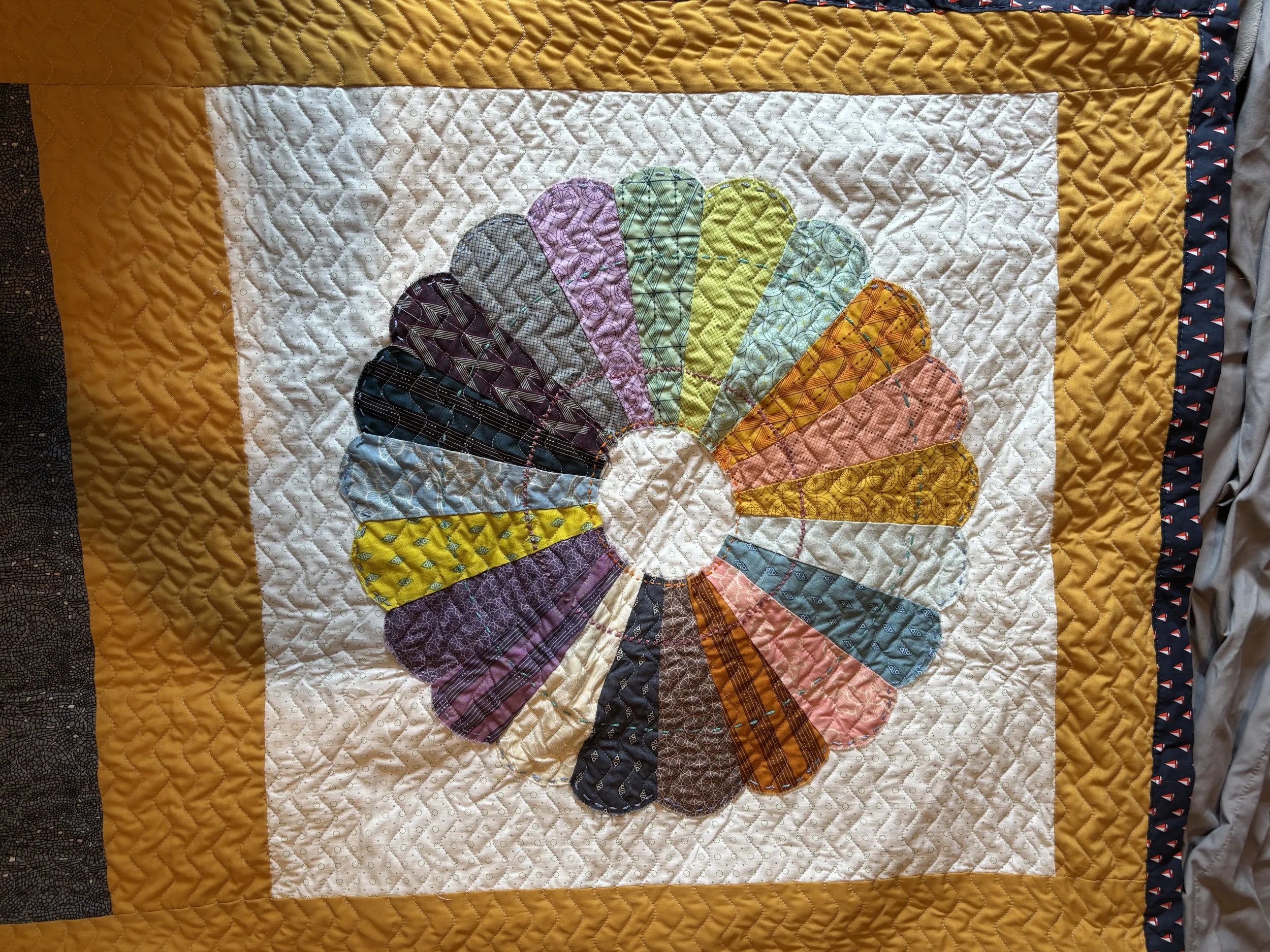 a type of quilt block known as a Dresden plate, which features a circular pattern of many colors on a light background