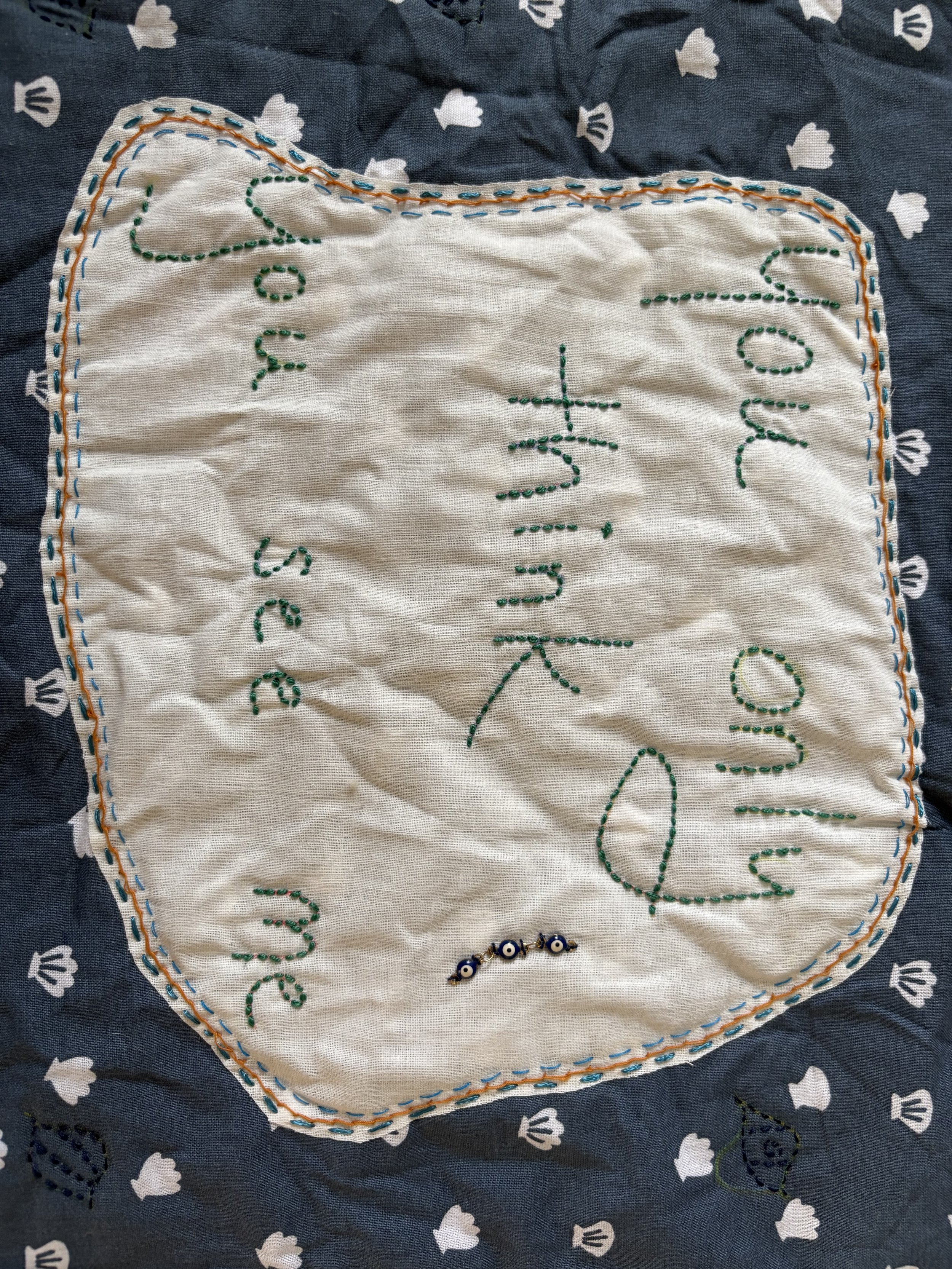the words "You only think you see me" embroidered in green on a white background