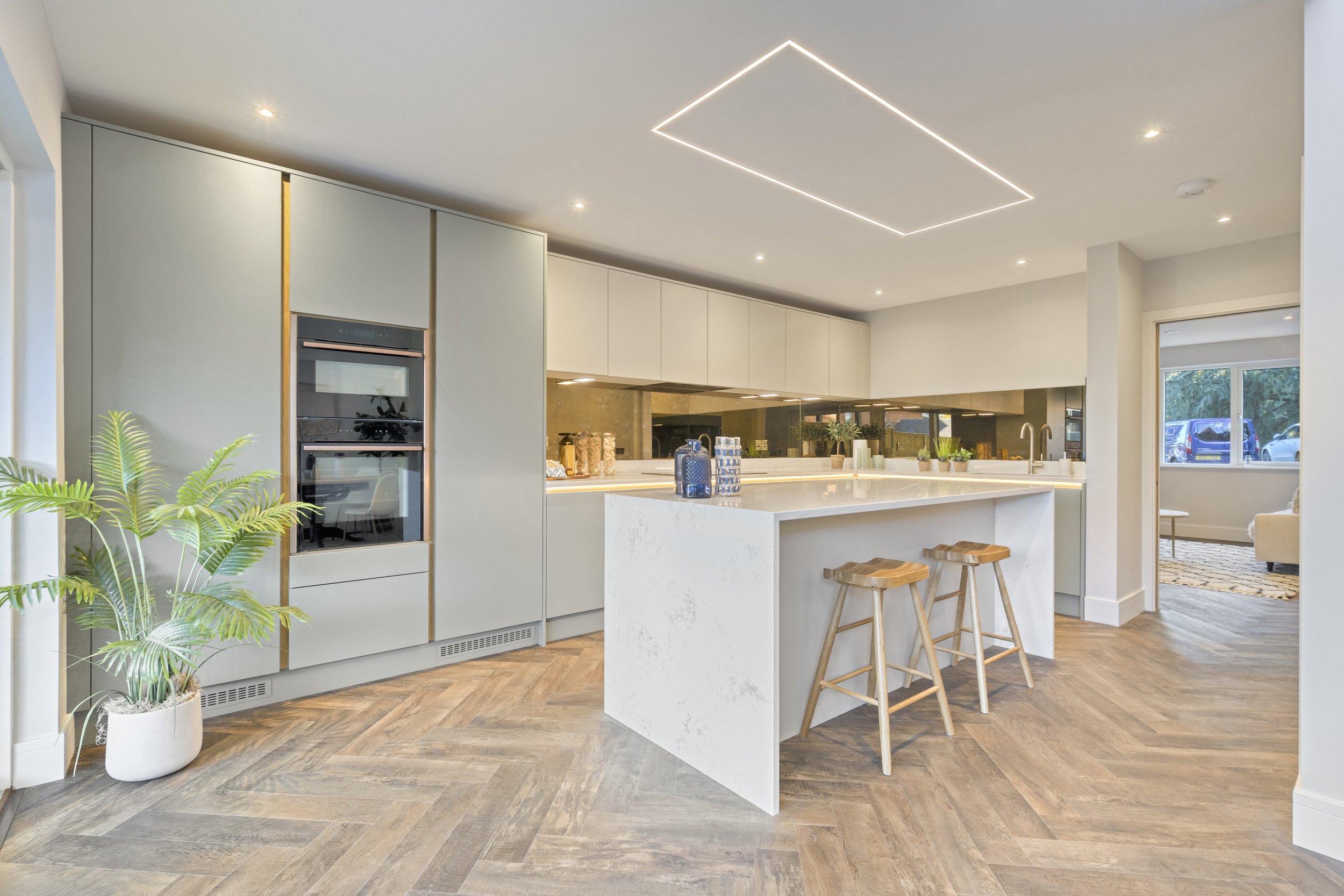 Hand painted Masterclass kitchen with quartz worktop and waterfall island. Bespoke LED lighting detail above the perimeter of the island.