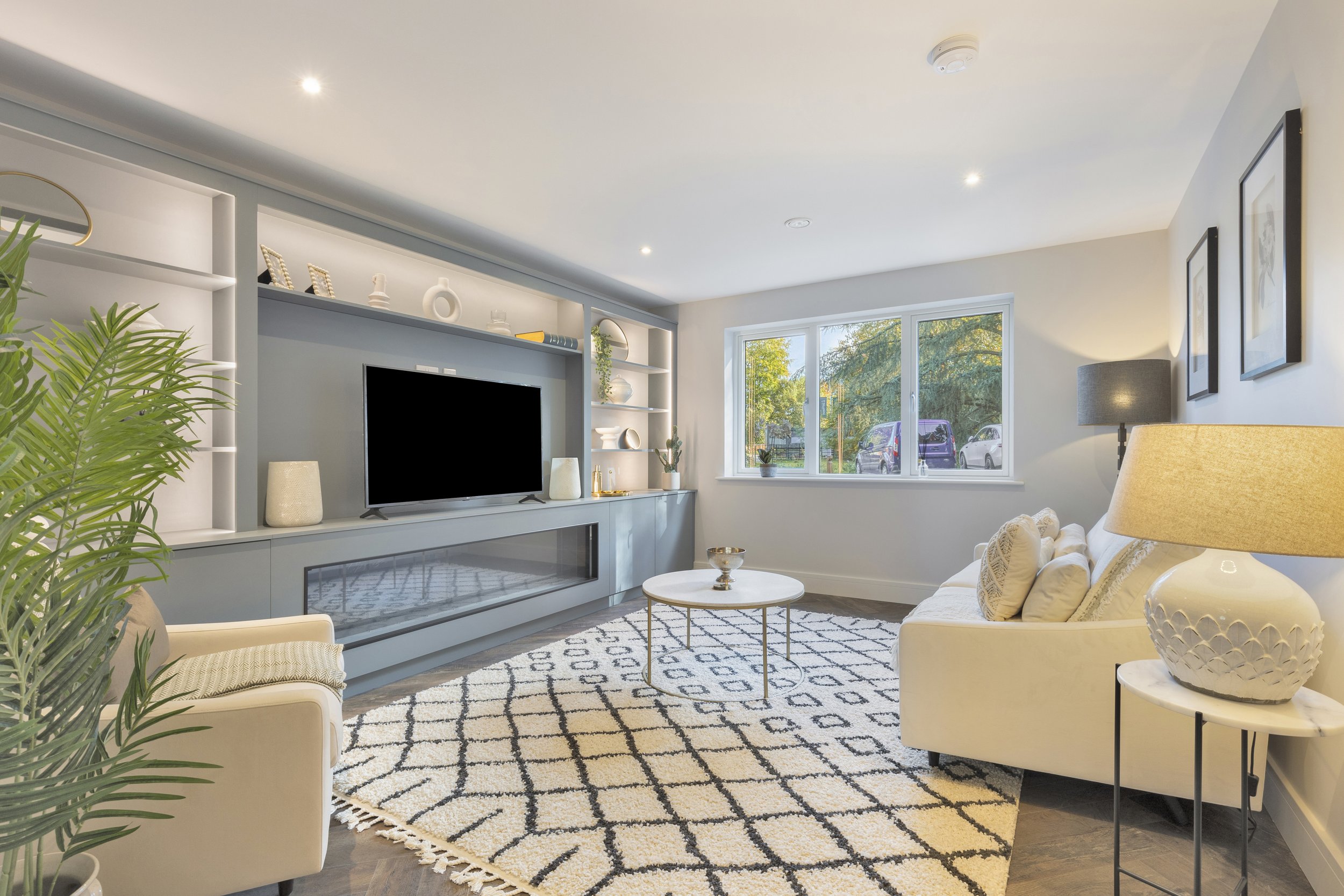 Ground floor living room with bespoke media unit and electric fireplace.