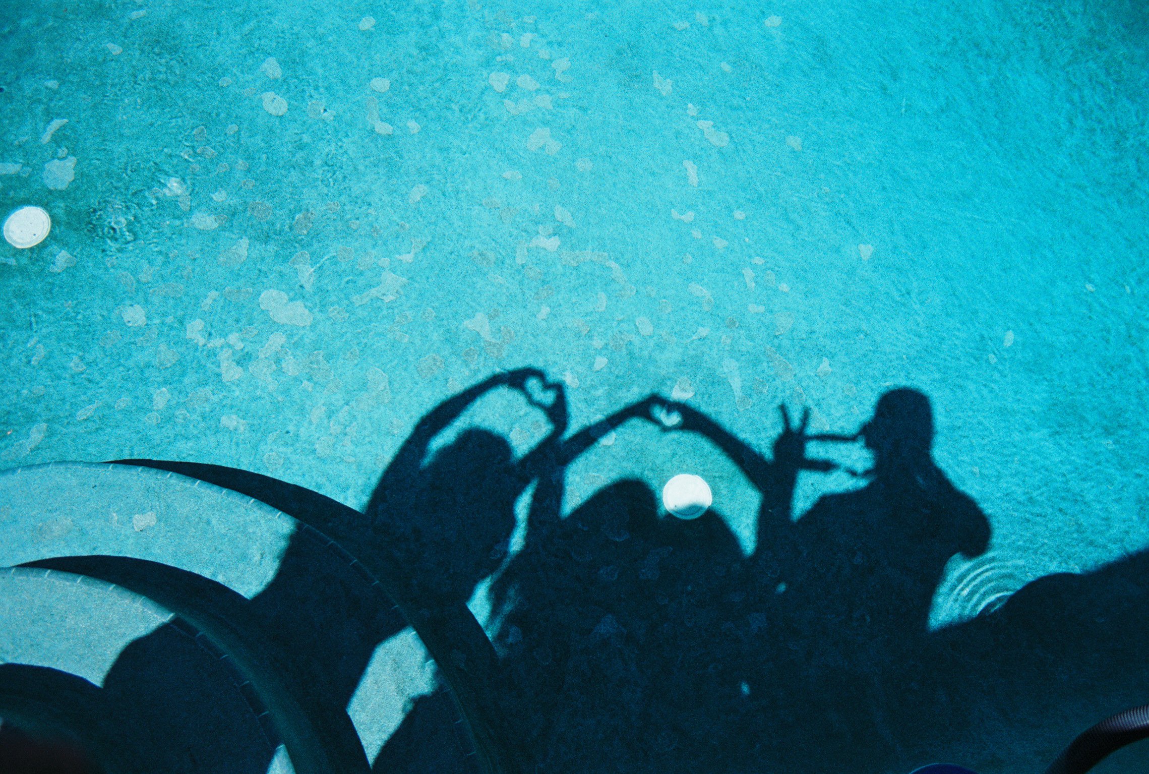 Shadow of a three people near a pool