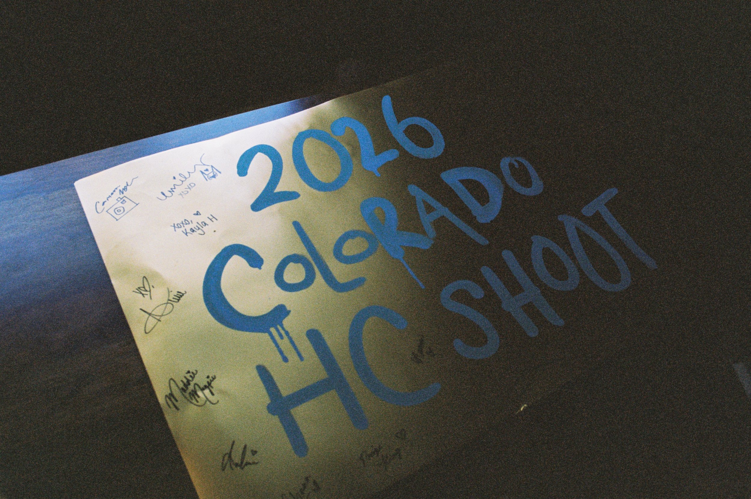 A poster for the 2026 Colorado HC Show, with handwritten signatures and messages in blue ink, on a yellowish background. 