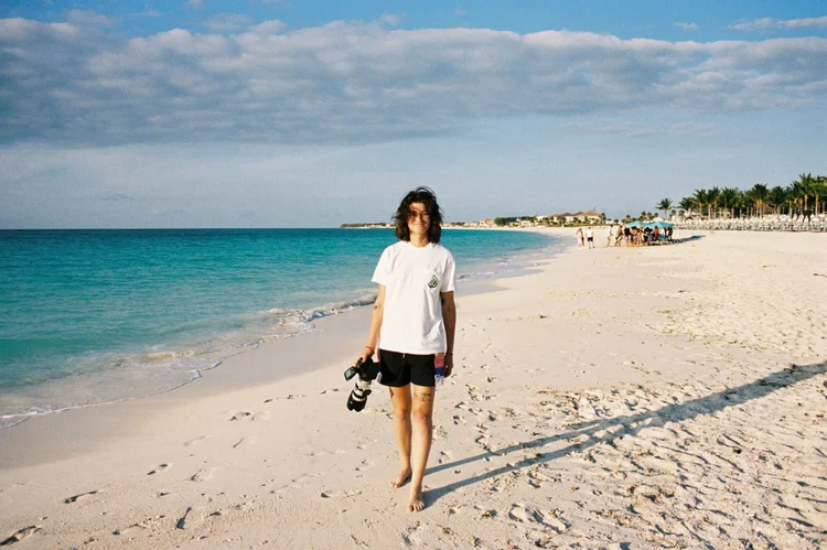 Hooters Calendar photographer Delaney Holloway walking the beach with a camera