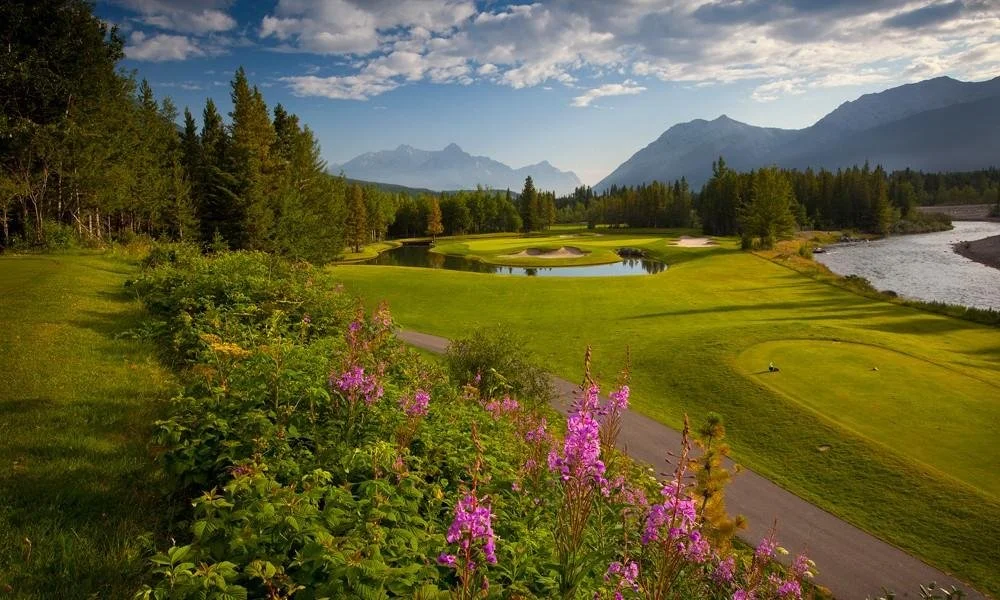lbeautiful mt. kidd golf course in canmore with green fairways and pink floral lining the fairways.