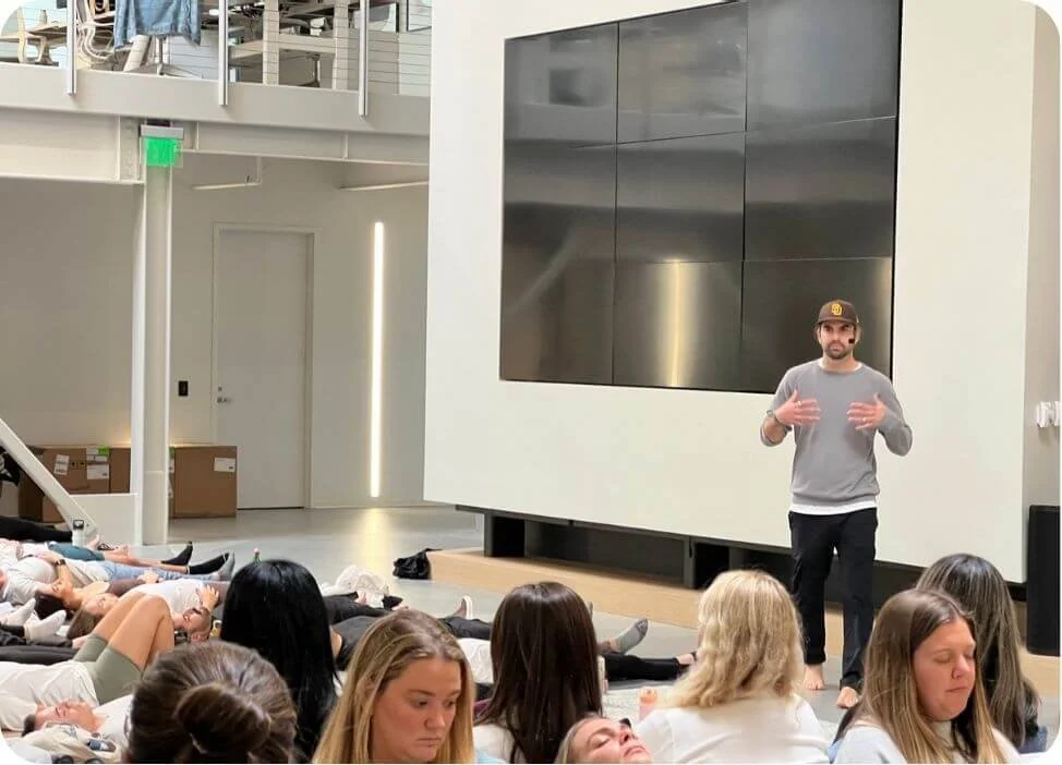 Reis Paluso giving a presentation to the entire Vuori staff at the opening of their new headquarters in Carlsbad, CA