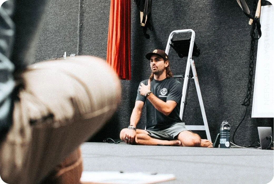 Reis Paluso teaching a breath workshop to athletes for Deep End Fitness in a gym.