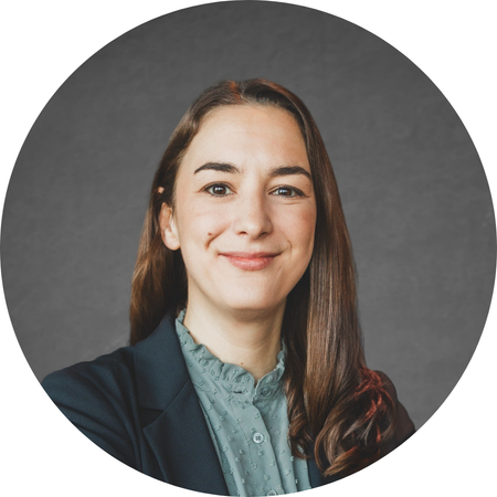 Portrait of Betsy Pearl of CUNY ISLG in front of a gray background.