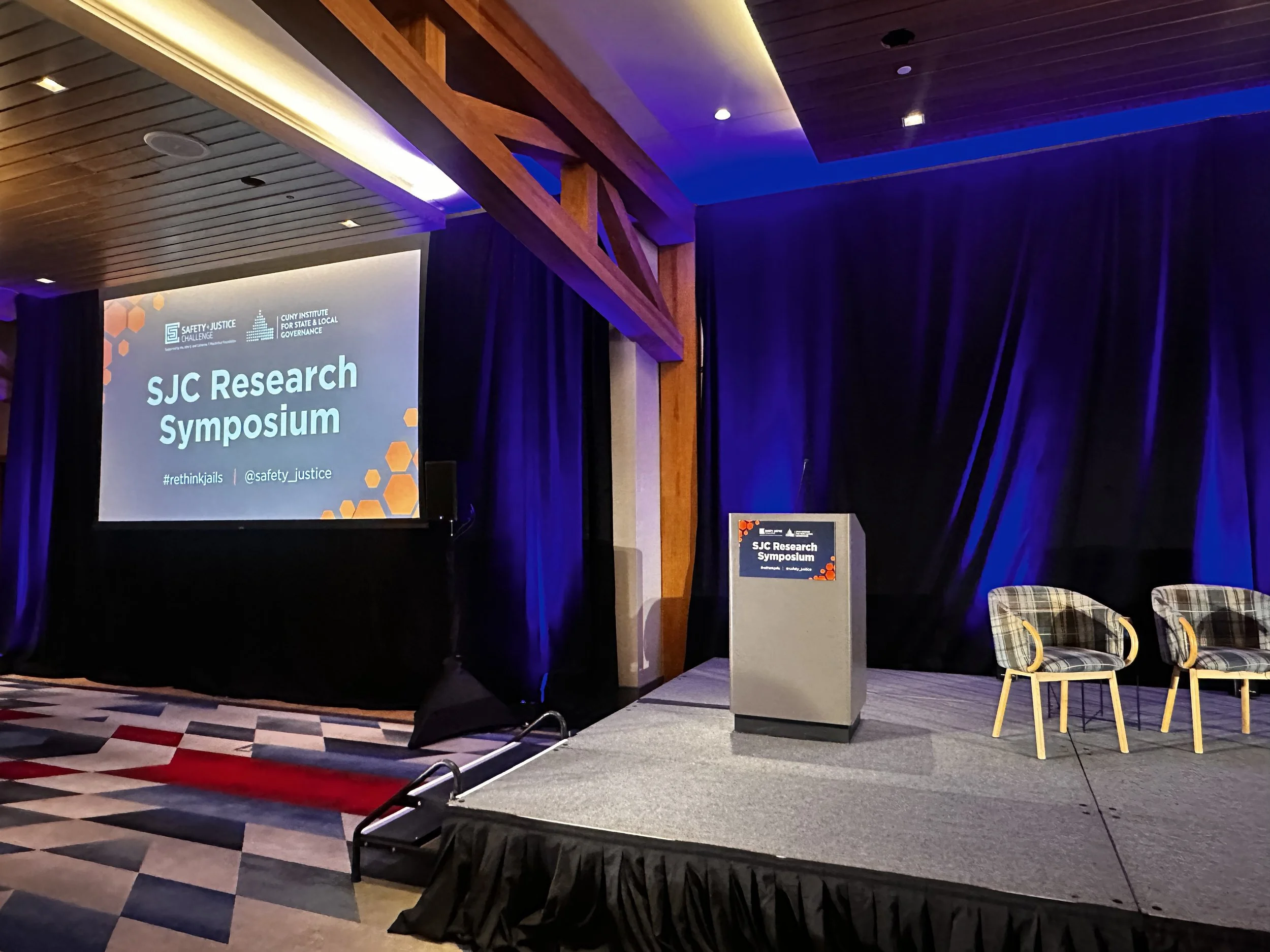 The podium and presentation screen at the 2026 SJC Research Symposium