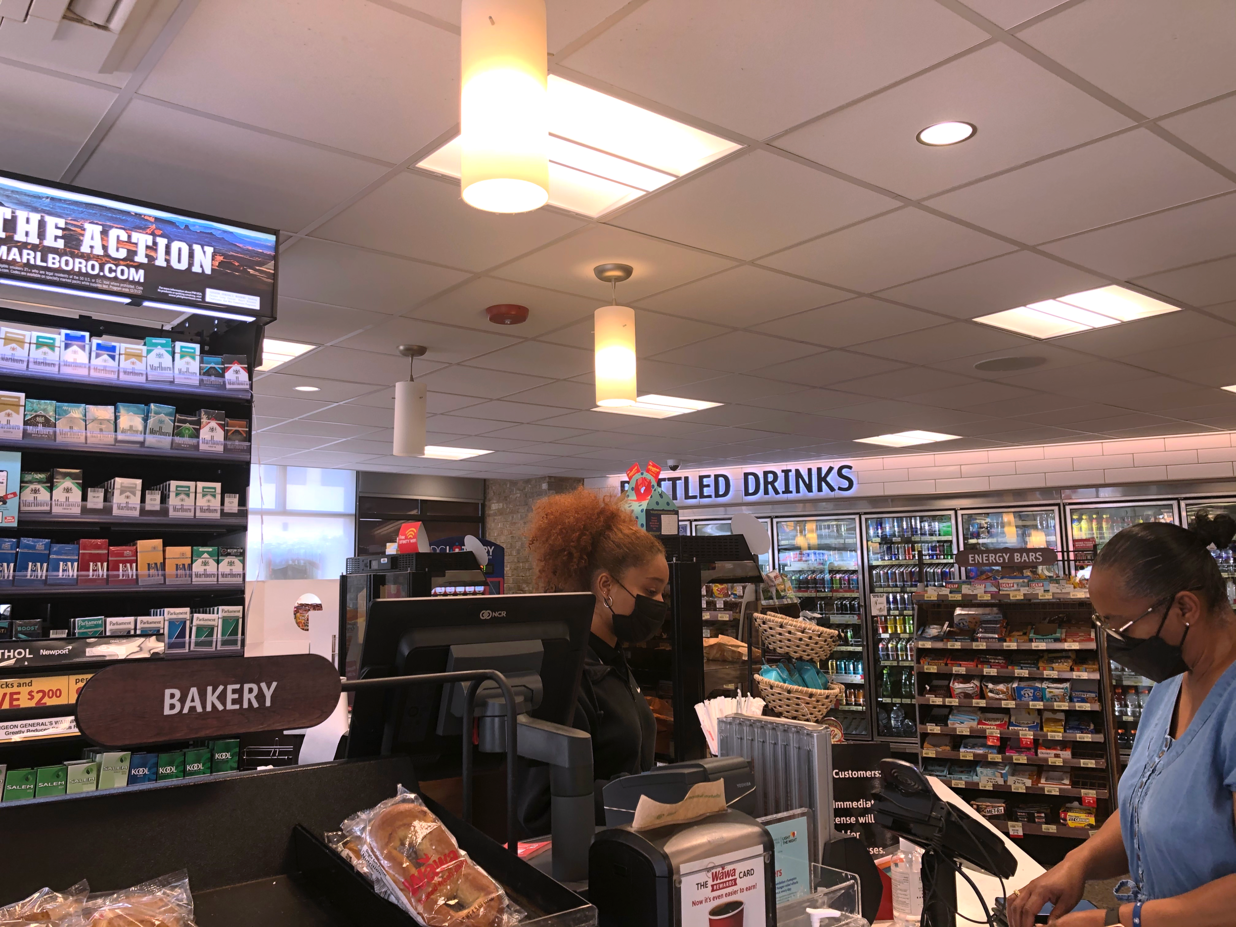 Wawa Cashier, Laressa Maynard, helps local customer. Maynard said that many customers have been compliant with wearing masks.&nbsp;
