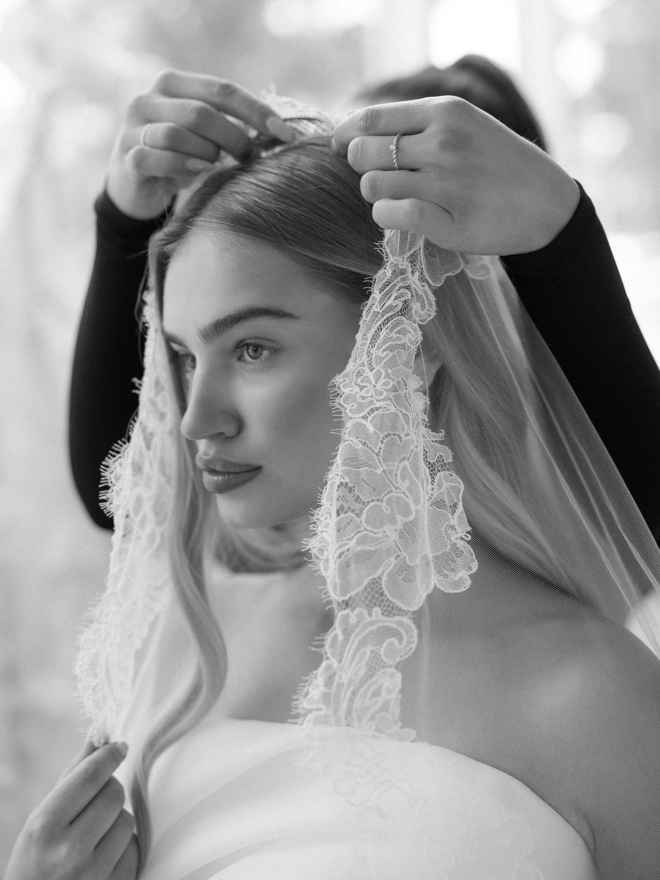 Stunning bride having a veil appointment at the bridal boutique with locations in regina, calgary , edmonton and Saskatoon. she is trying on a beautiful Chantilly lace veil with her stylist at The Bridal Boutique