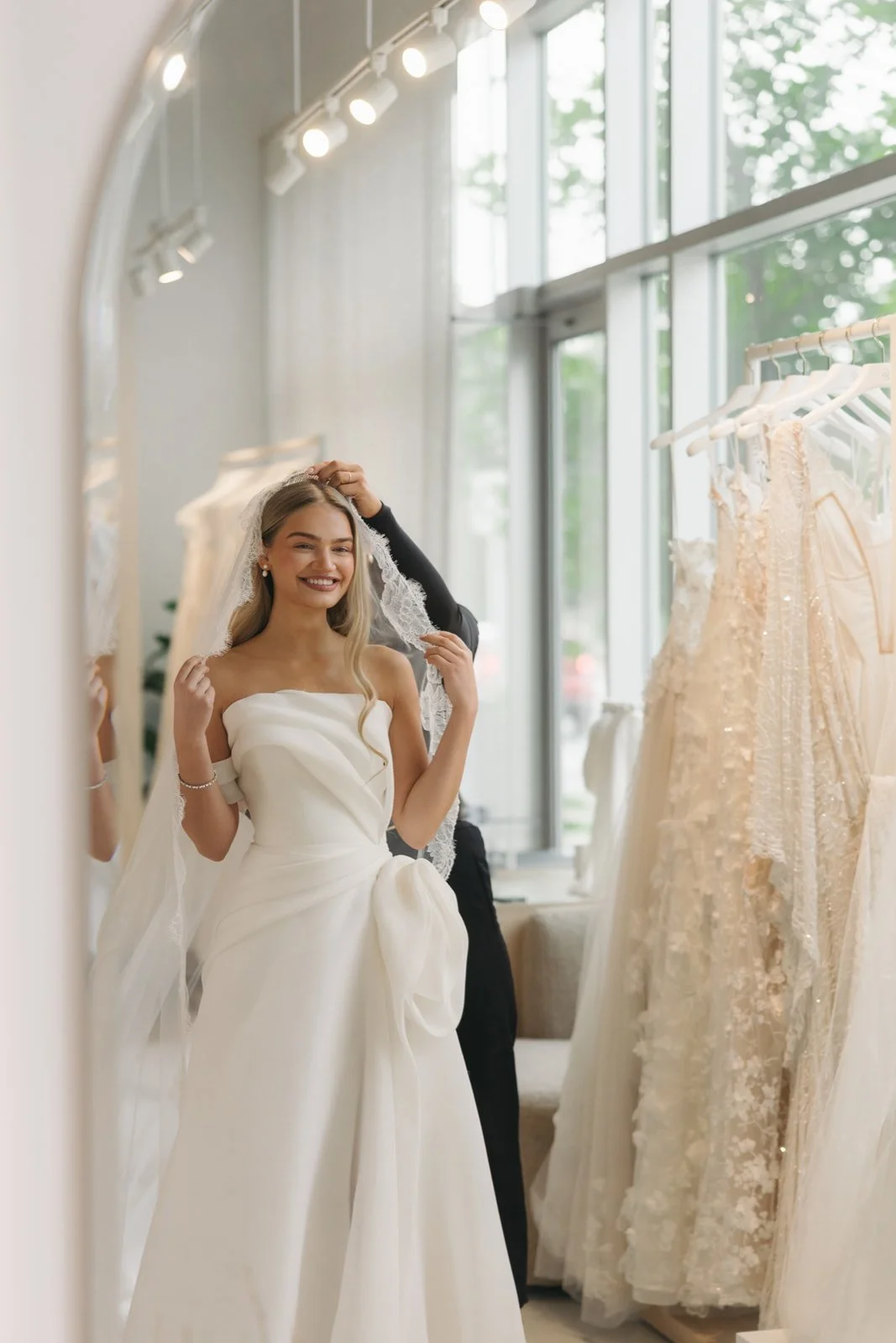 Bride trying on a SAINT Bridal Couture wedding dress with a stylist at The Bridal Boutique.