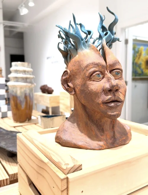 A ceramic bust with blue flame like hair in the gallery