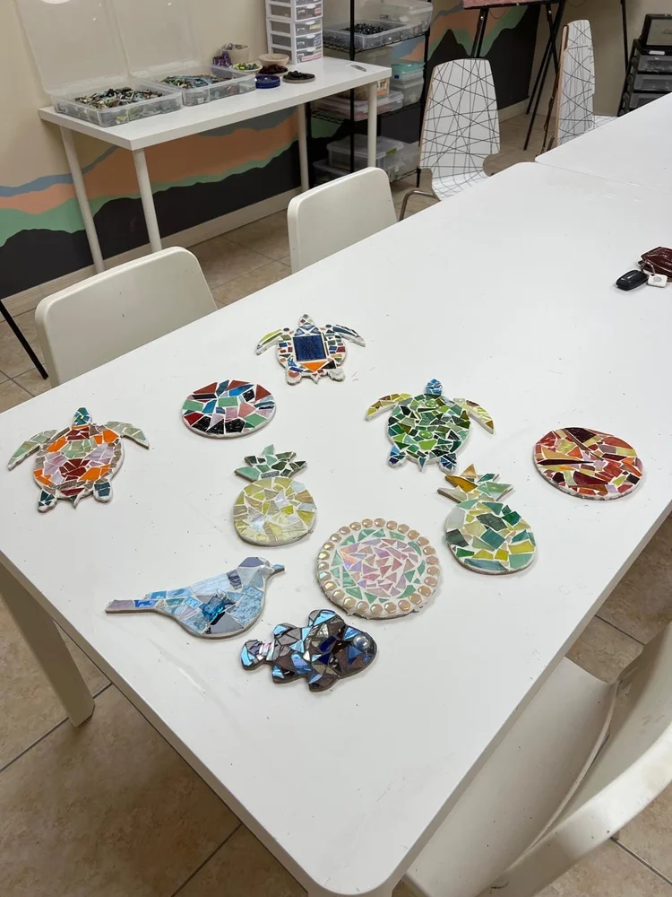 Finished mosaics by Gasper Arts artists laid out on a table
