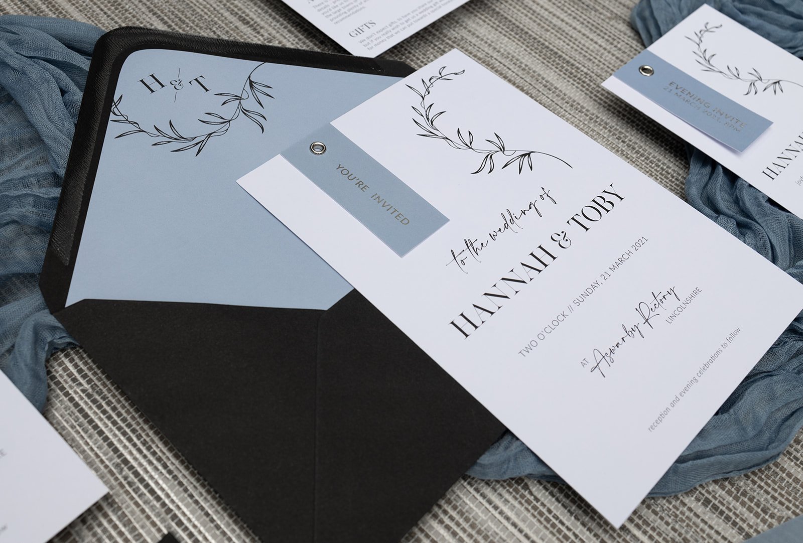 Minimalist Luxe botanical wedding invitation in Dusky Blue, with silver-foiled tags.