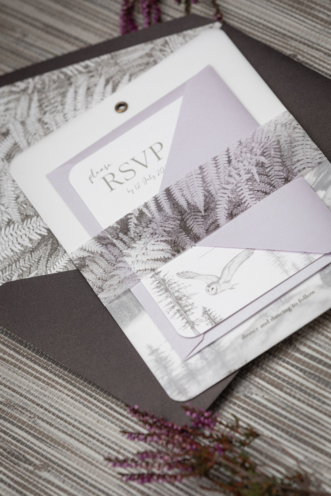 Day invite and RSVP bound with bronzed ferns vellum belly band, shown with RSVP envelope in 'Shimmer Heather' and day invite envelope in 'Bronzed Peat'.