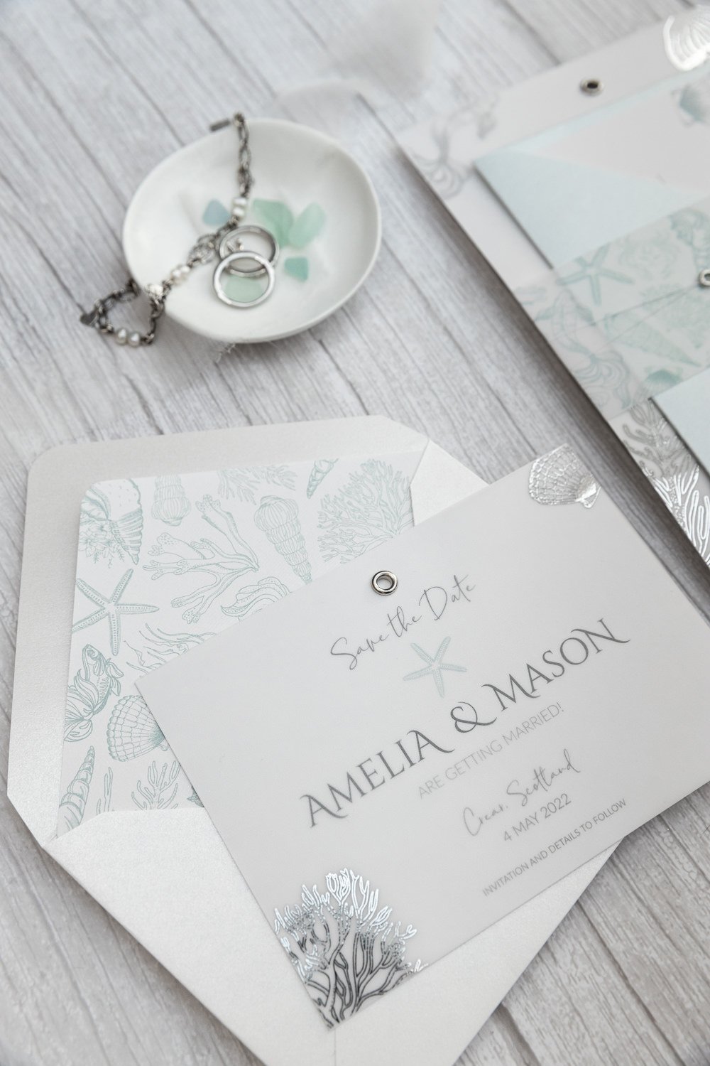 Beachcomber Sea Spray Save the Date, with silver-foiled sea illustrations vellum overlay, and lined 'Pearl Oyster' envelope