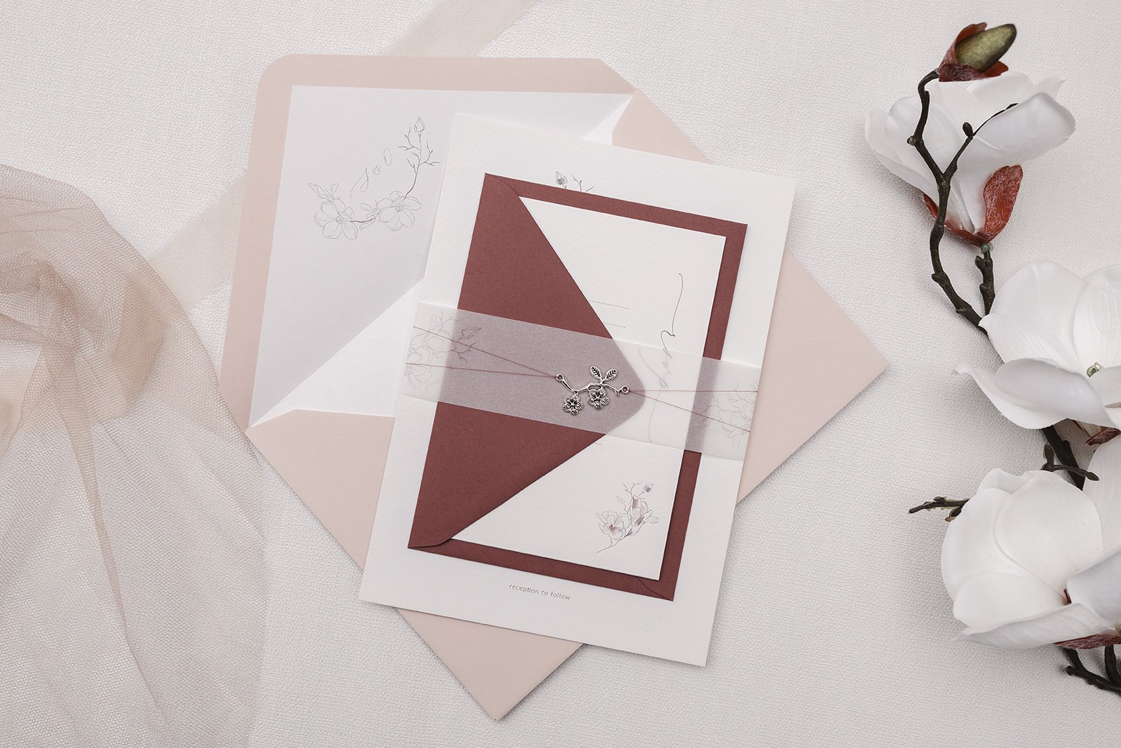 Grace collection Charmed Invite™ with Blush main envelope and Rosebud RSVP envelope and illustrated vellum belly band